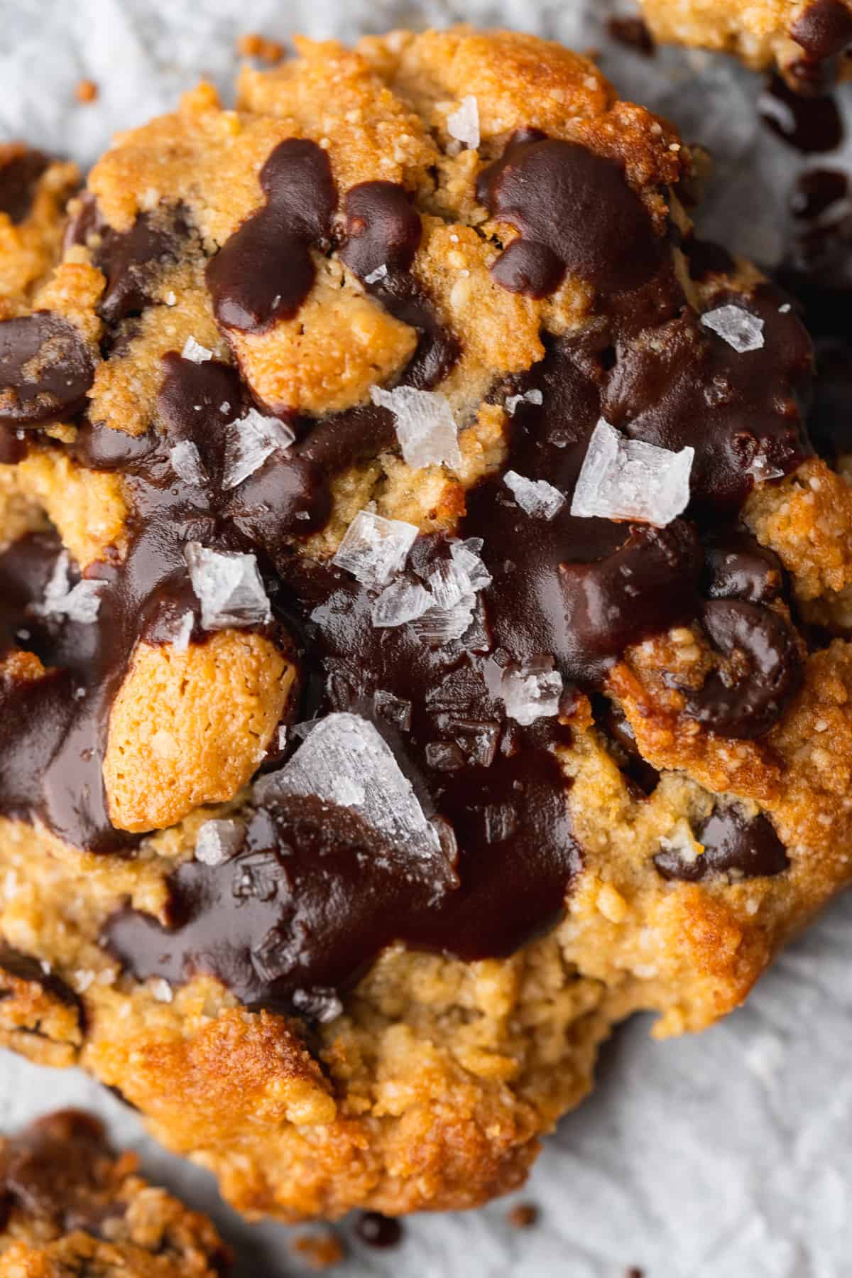 close up shot of a large keto peanut butter chocolate chip cookie with flakey sea salt