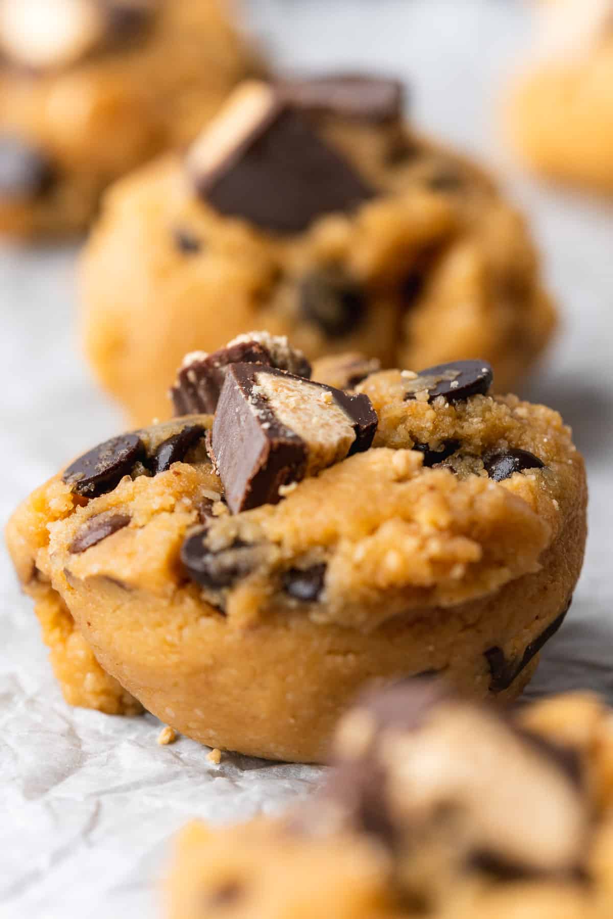 close up shot of a keto butter butter cookie dough ball with peanut butter cups in it 