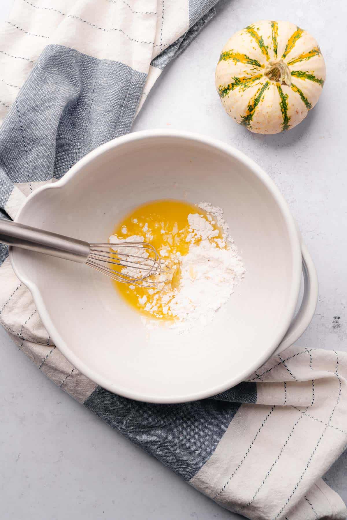 butter and sweetener in a ceramic mixing bowl