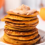 stack of pumpkin pancakes with whipped butter on top