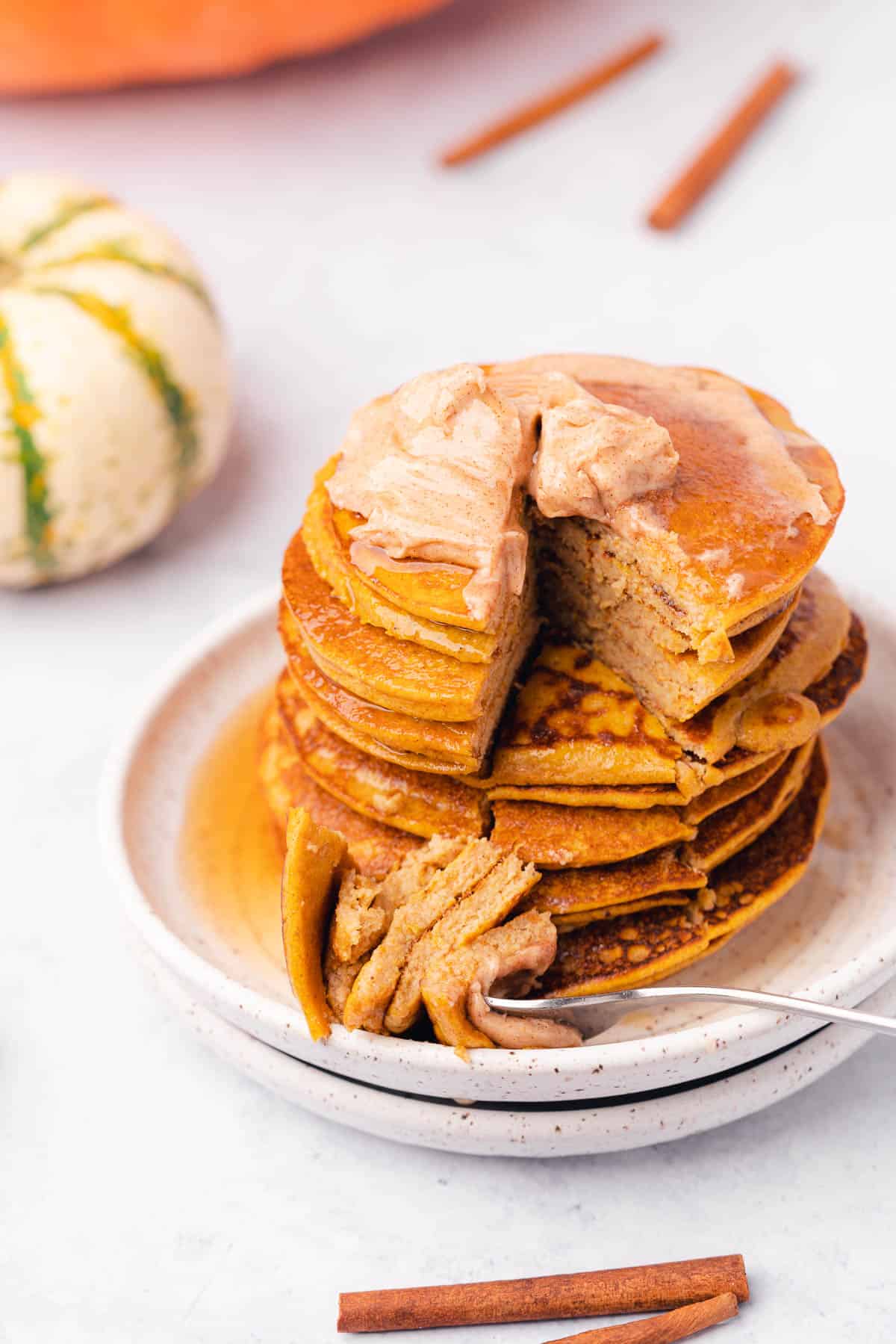 fluffy stack of keto pumpkin pancakes with whipped butter and a fork in the stack 