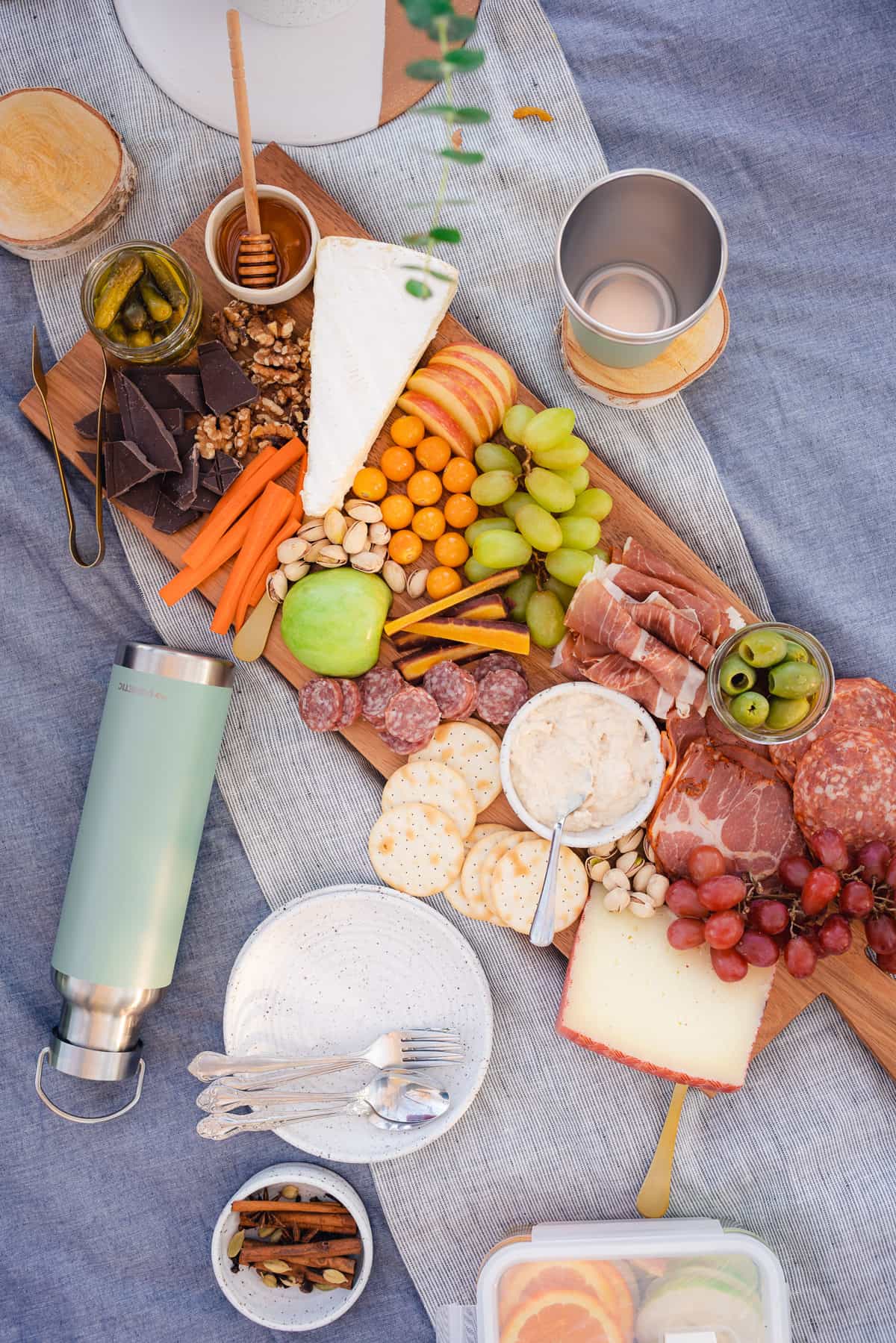 flat lay of a fall picnic date for two wit ha charcuterie board, wine and blankets