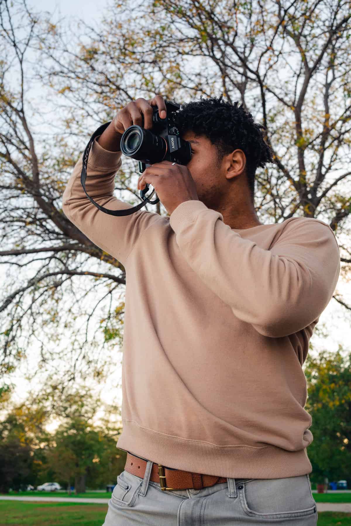photo of man looking off into the distance to photograph something in nature