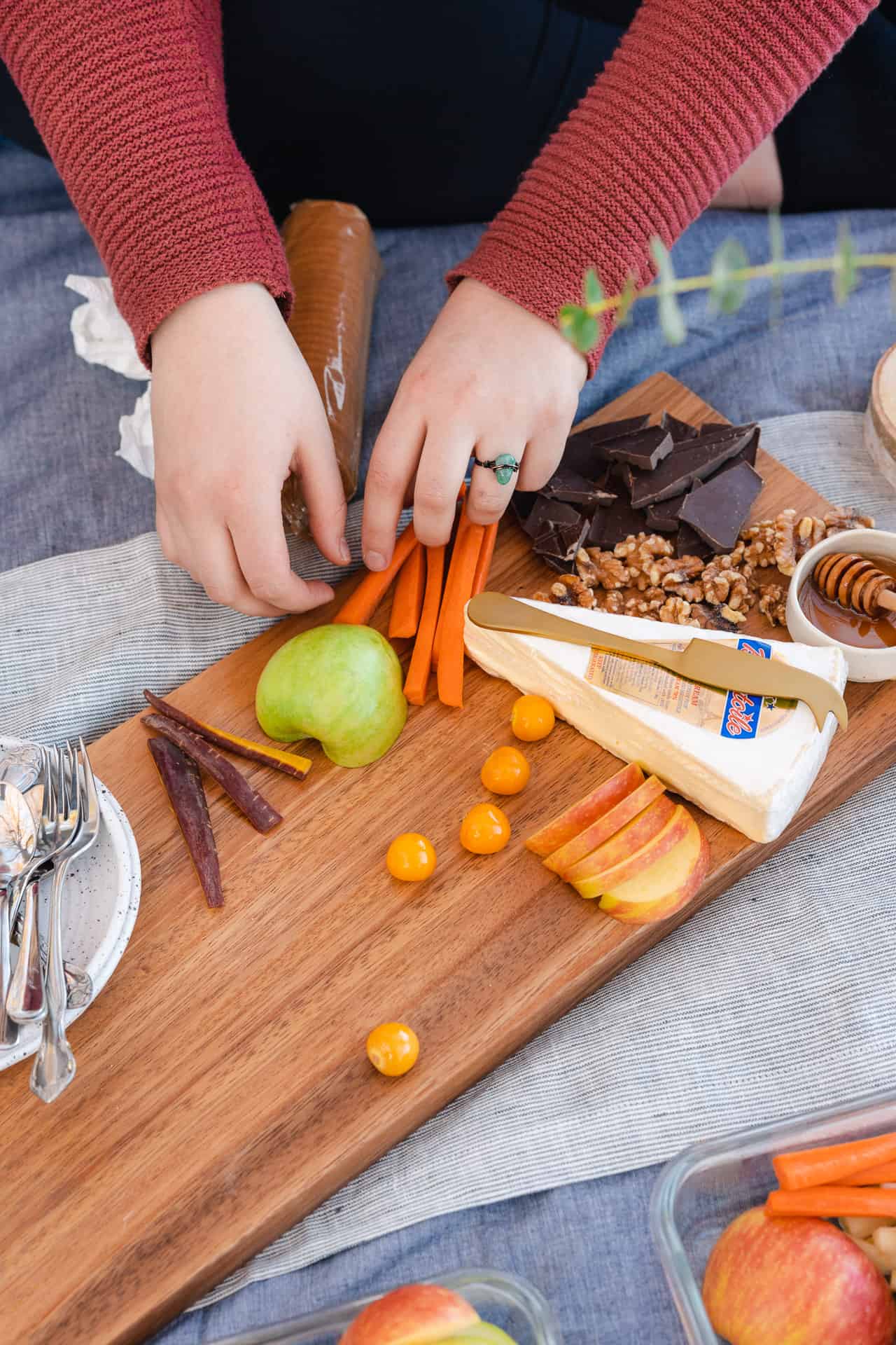 hands of a woman building a small charcuterie board