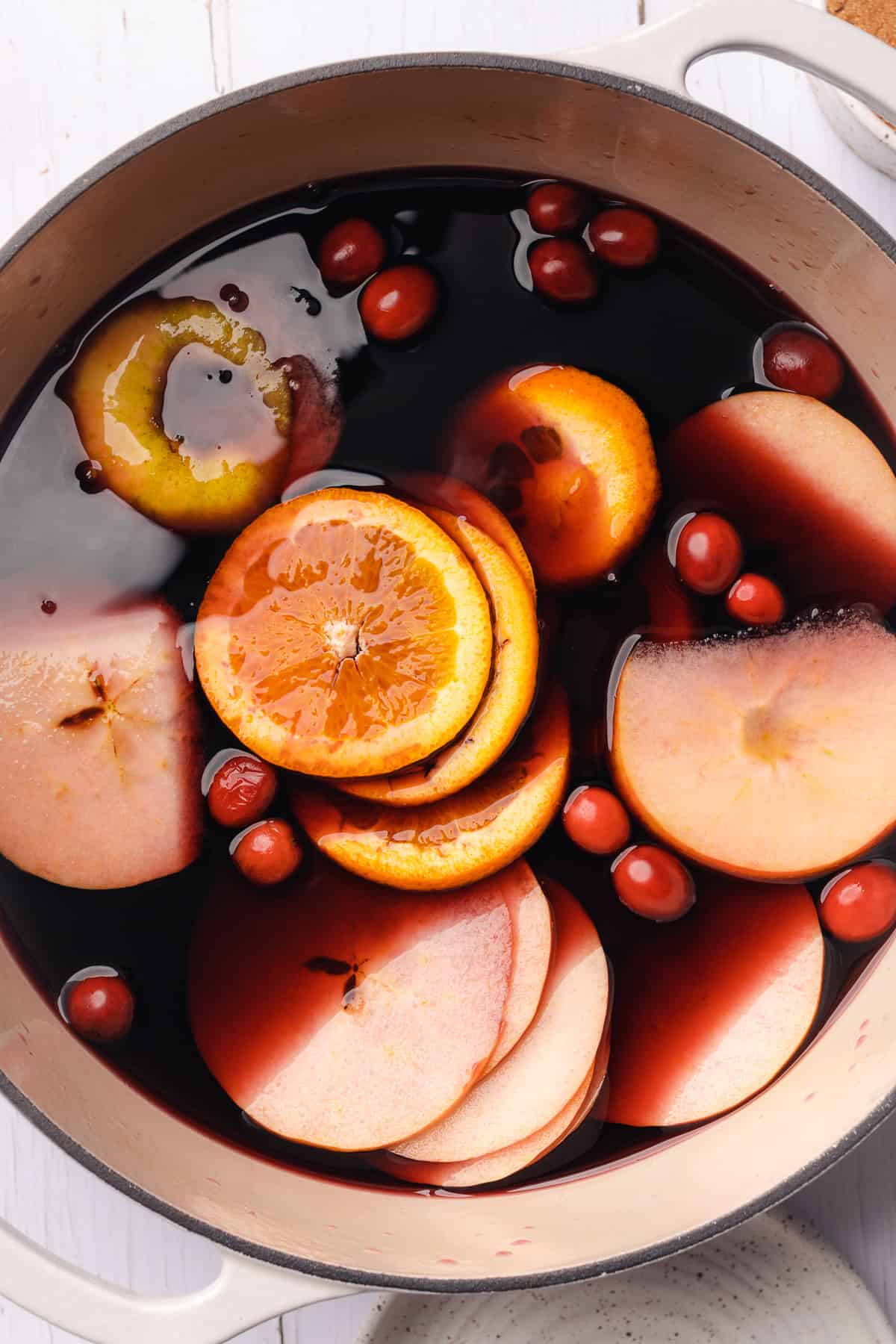 fruit added to dutch oven with red wine to make mulled wine 