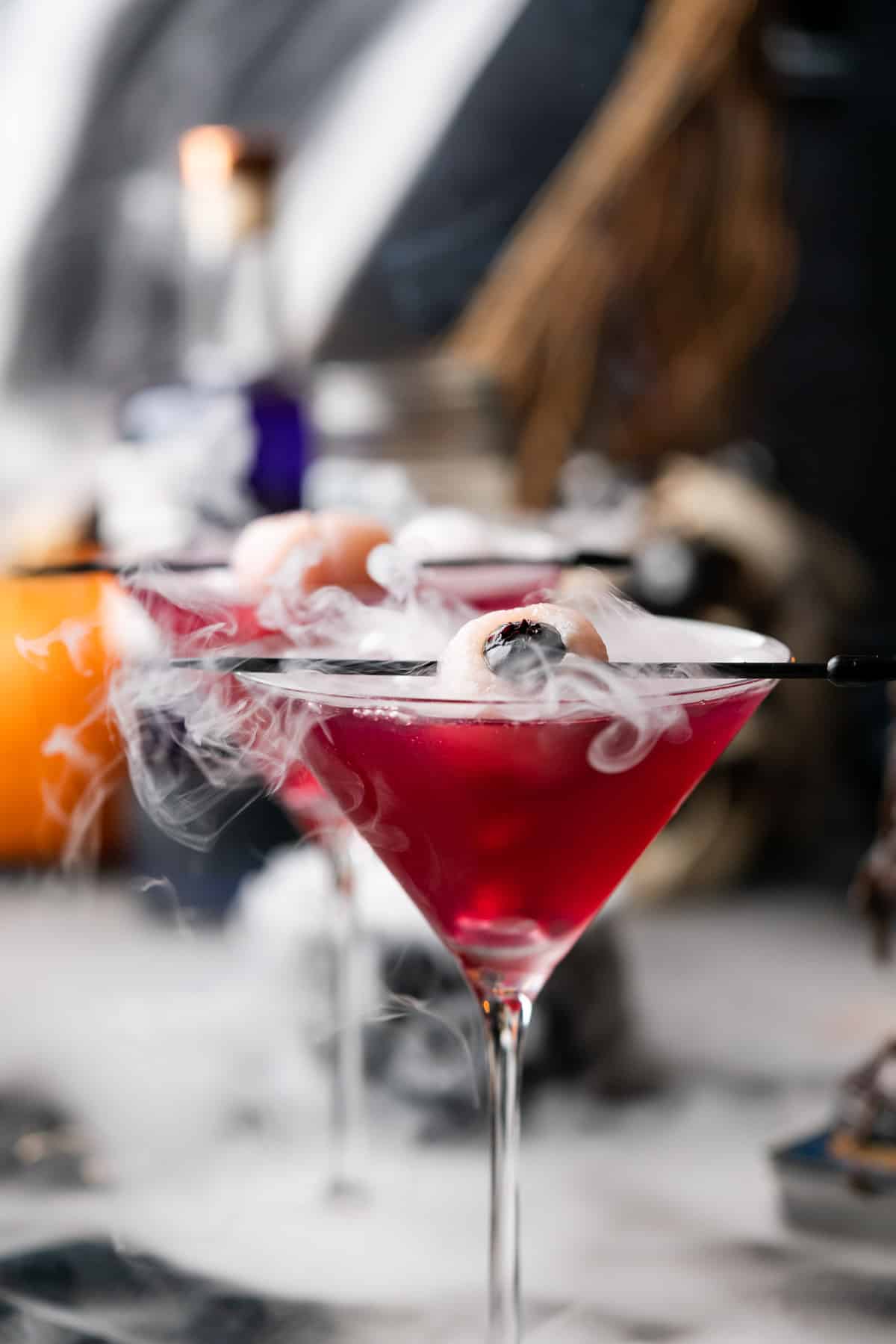 bubbling purple people eater cocktail with dry ice and a lychee eyeball for Halloween