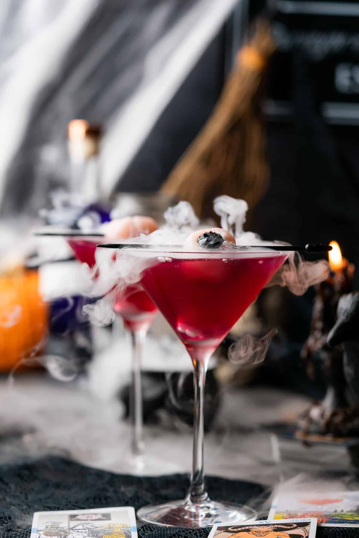 purple gin cocktails or purple people eater drinks for halloween with dry ice and a lychee eyeball