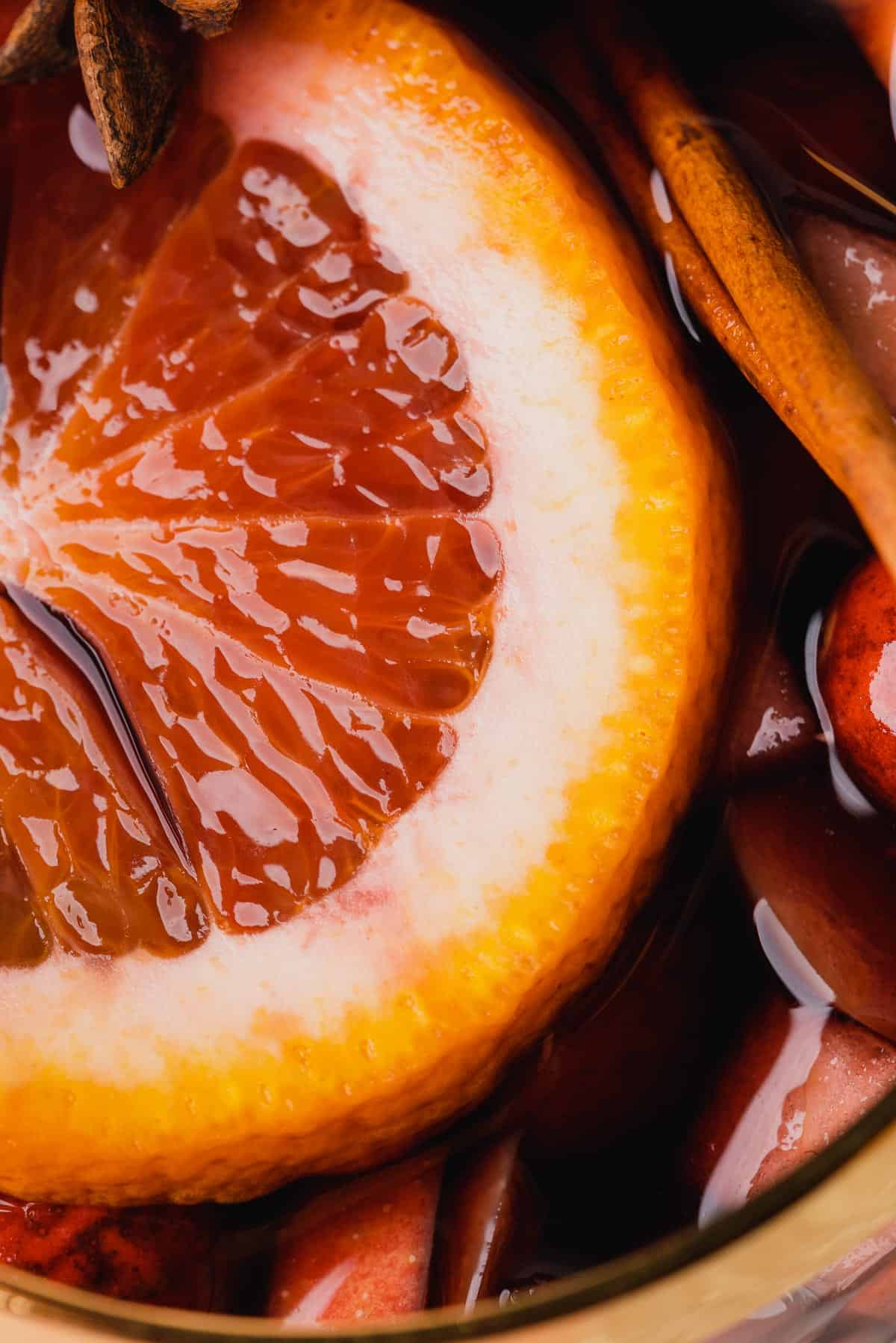 macro shot of bourbon sangria with a round of blood orange on top 