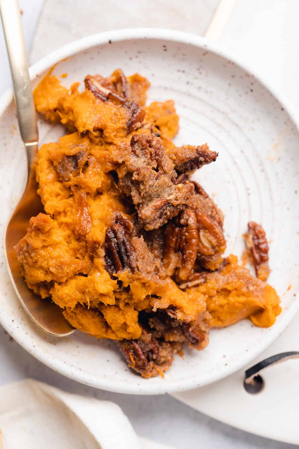 close up shot of sweet potato casserole with a pecan praline topping