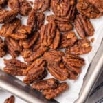 corner of a baking sheet with candied pecans