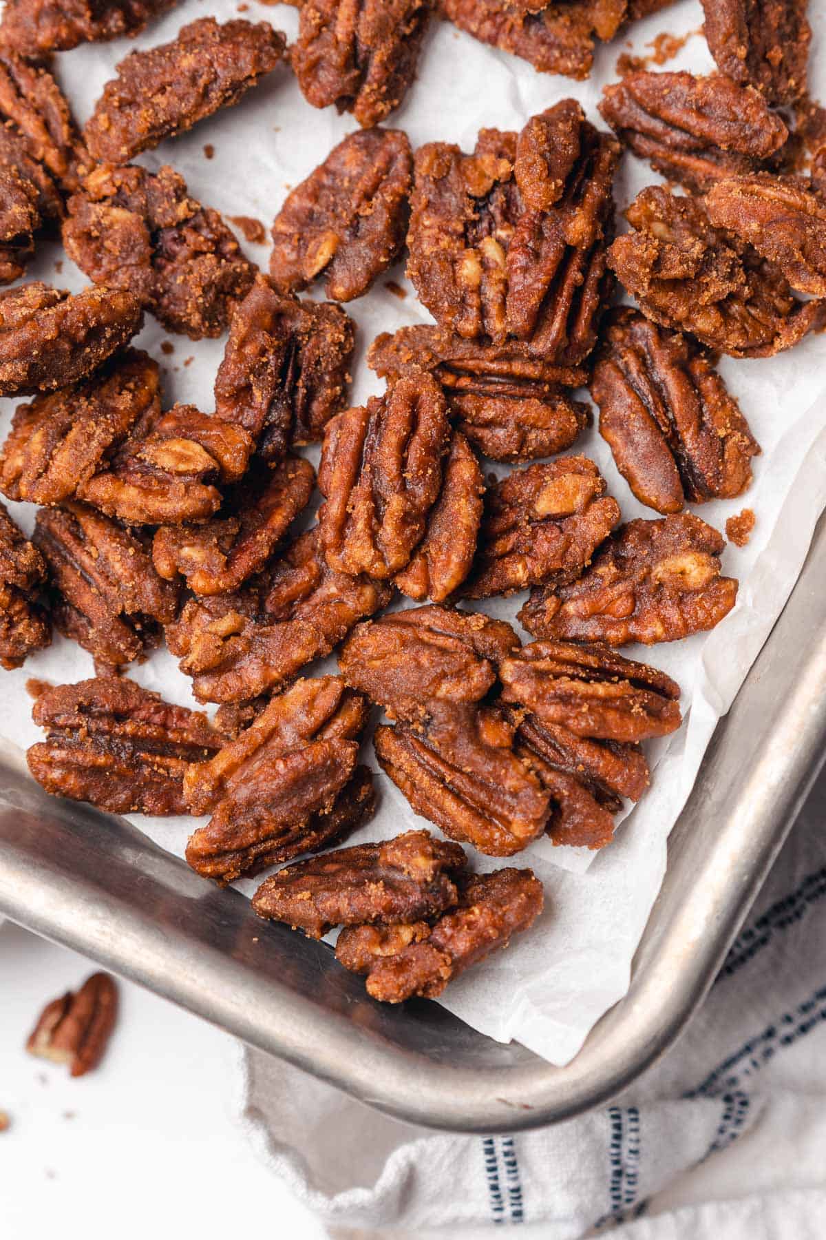 corner of a baking sheet with candied pecans