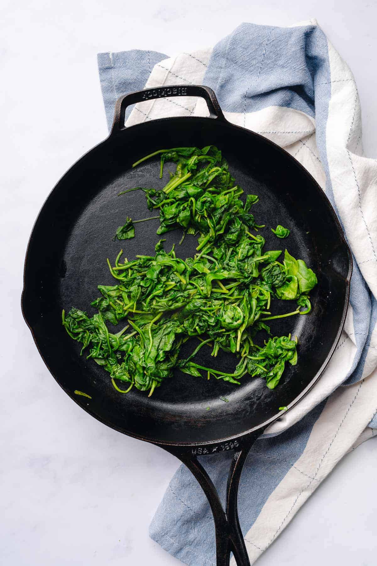 wilted spinach in a cast iron skillet