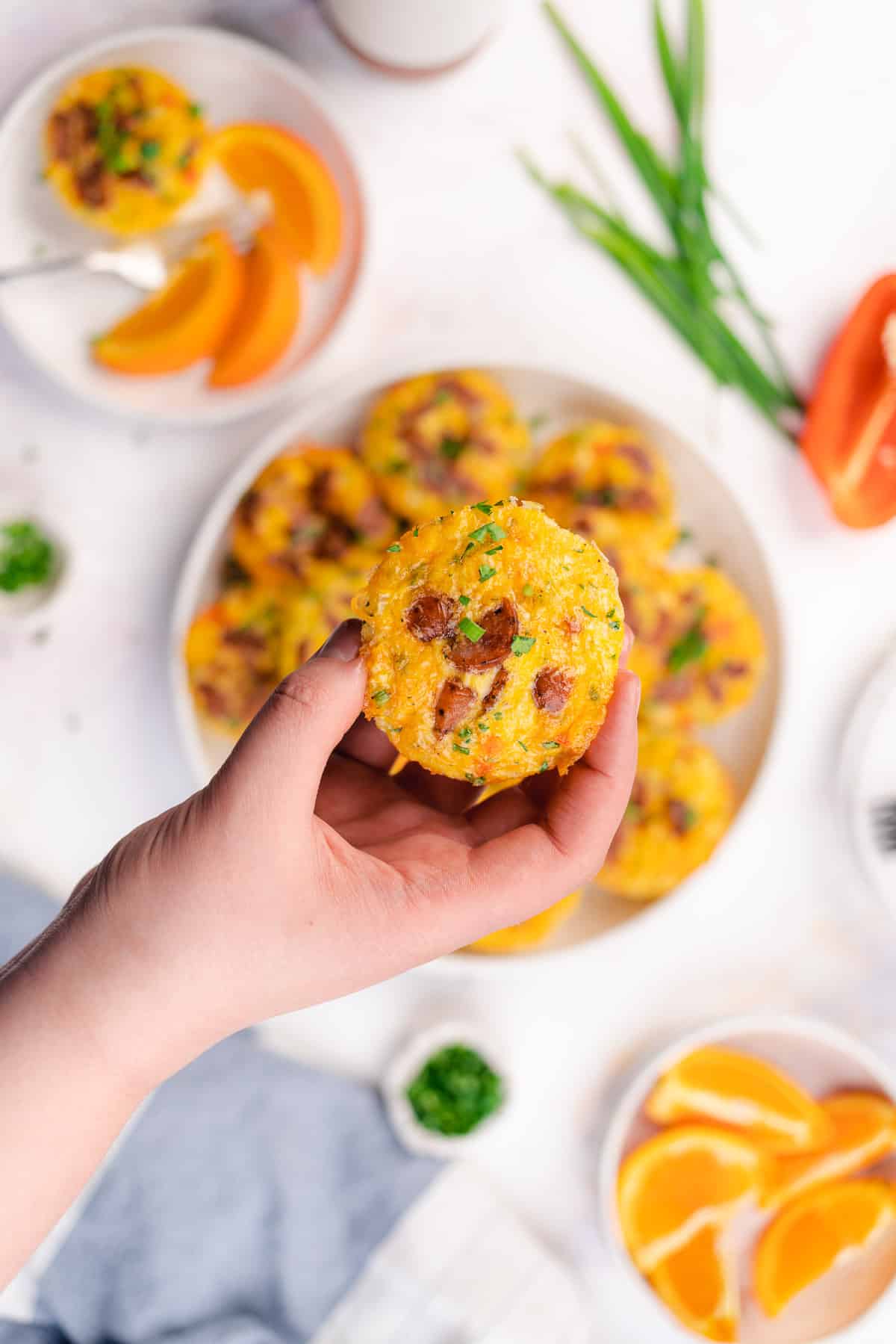 hand held sausage and egg muffin cup with cheese and bell peppers