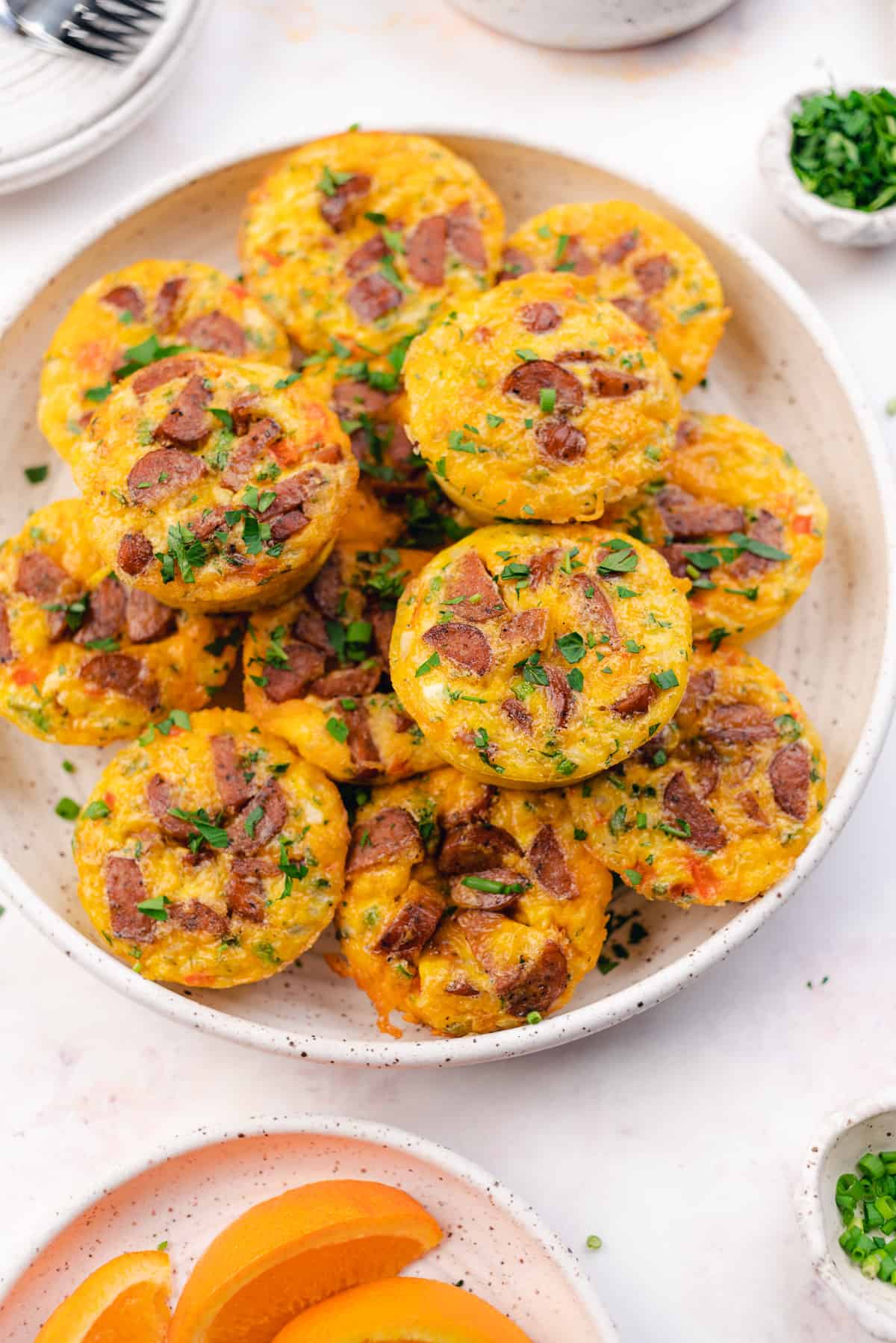 plate of sausage and egg muffins with cheese, bell peppers, chives and parlsey