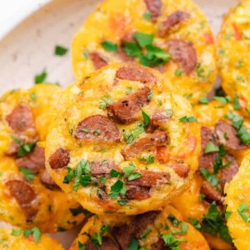 close up shot of sausage and egg muffins with cheese bell peppers chives and parsley