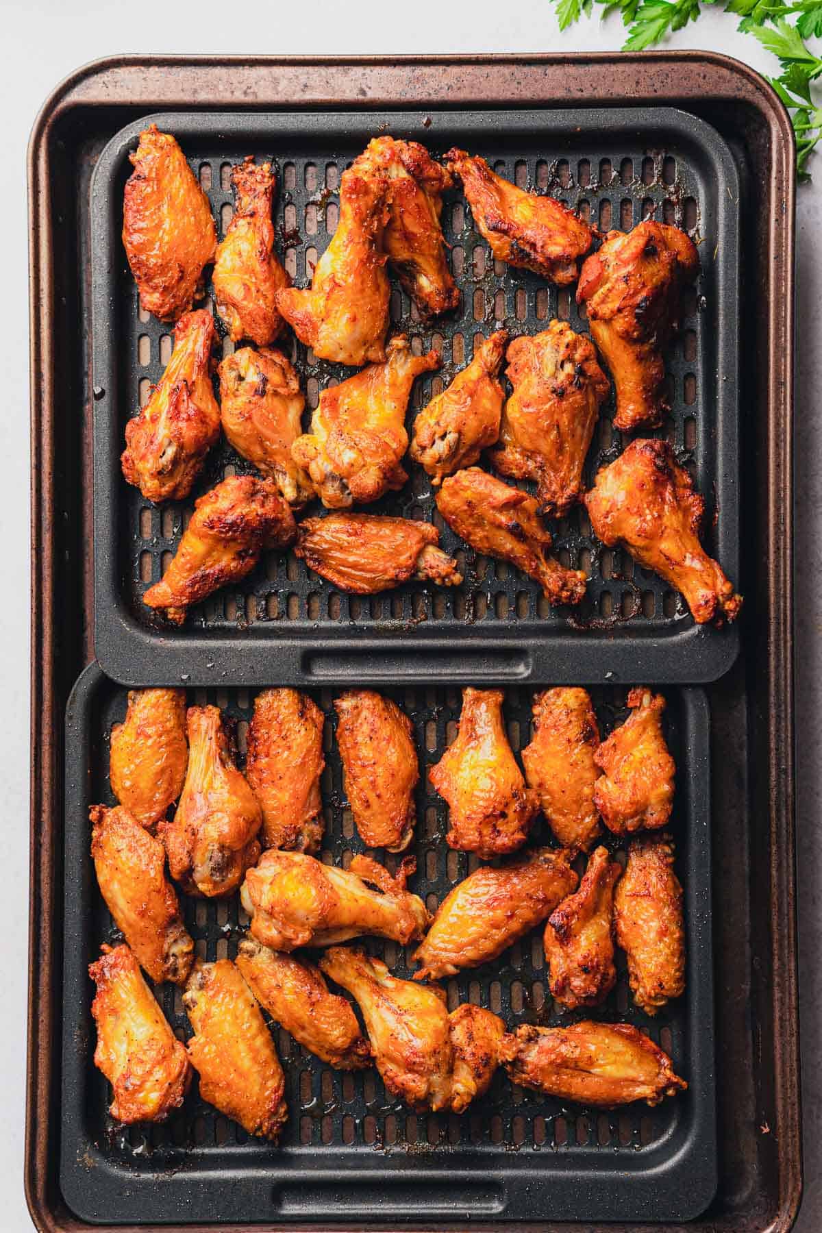 cooked brown and crispy chicken wings on trays 