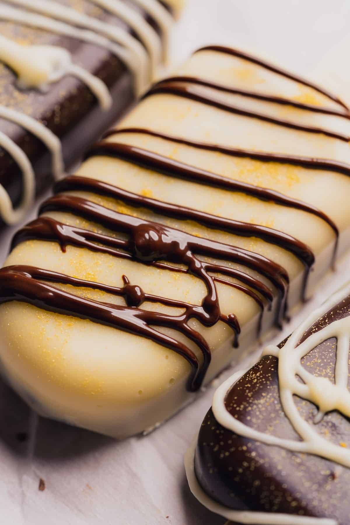 beautiful close up shot of a white chocolate cakesicle with dark chocolate drizzle