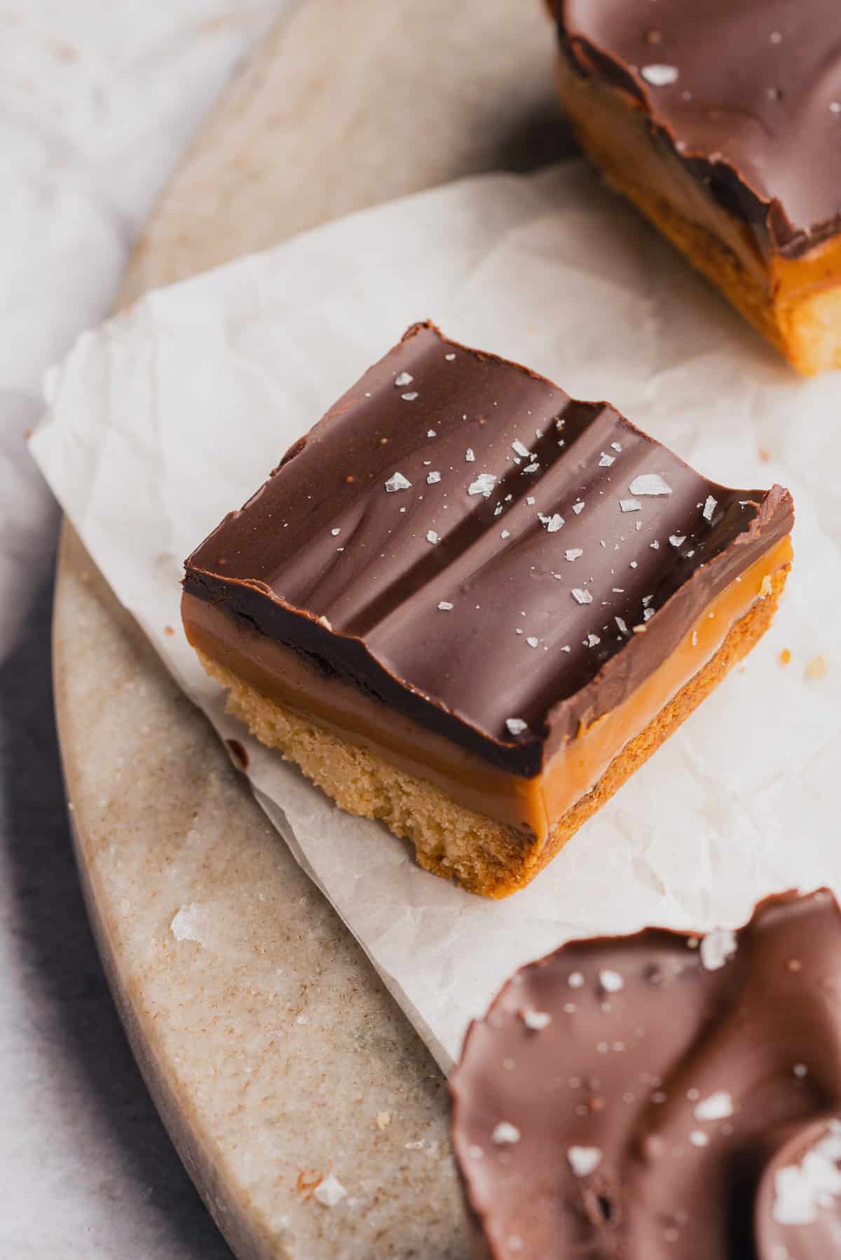 photo of a gluten free caramel slice with chocolate and topped with sea salt 
