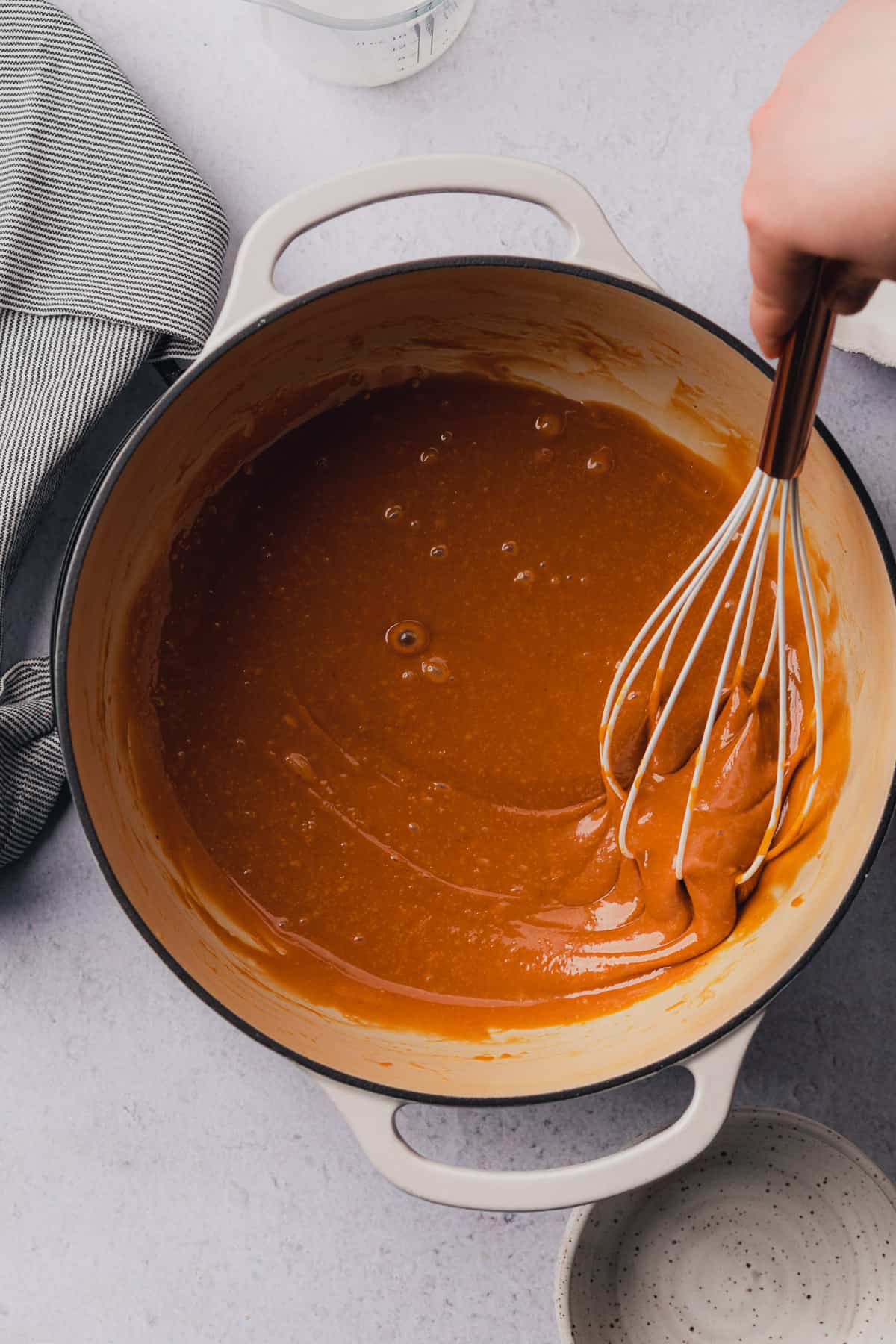 whisking caramel together in an enameled dutch oven