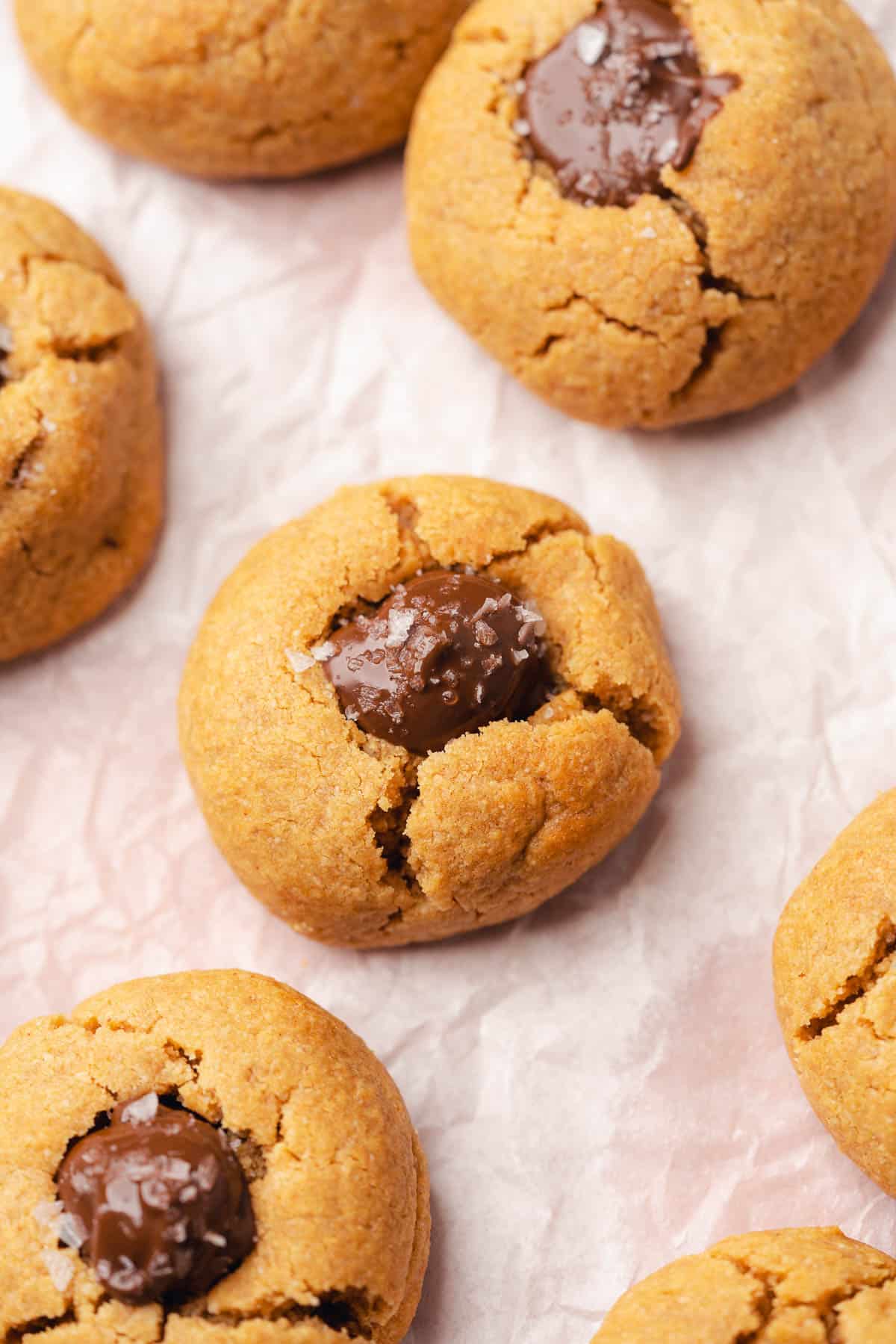 close up shot of a peanut butter blossom cookie sprinkled with flakey sea salt 