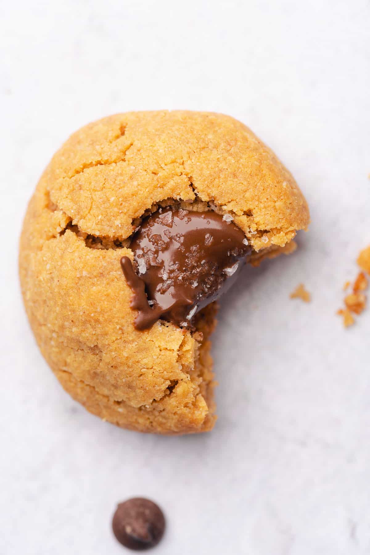 bite taken out of a crinkly gluten free peanut butter blossom cookie