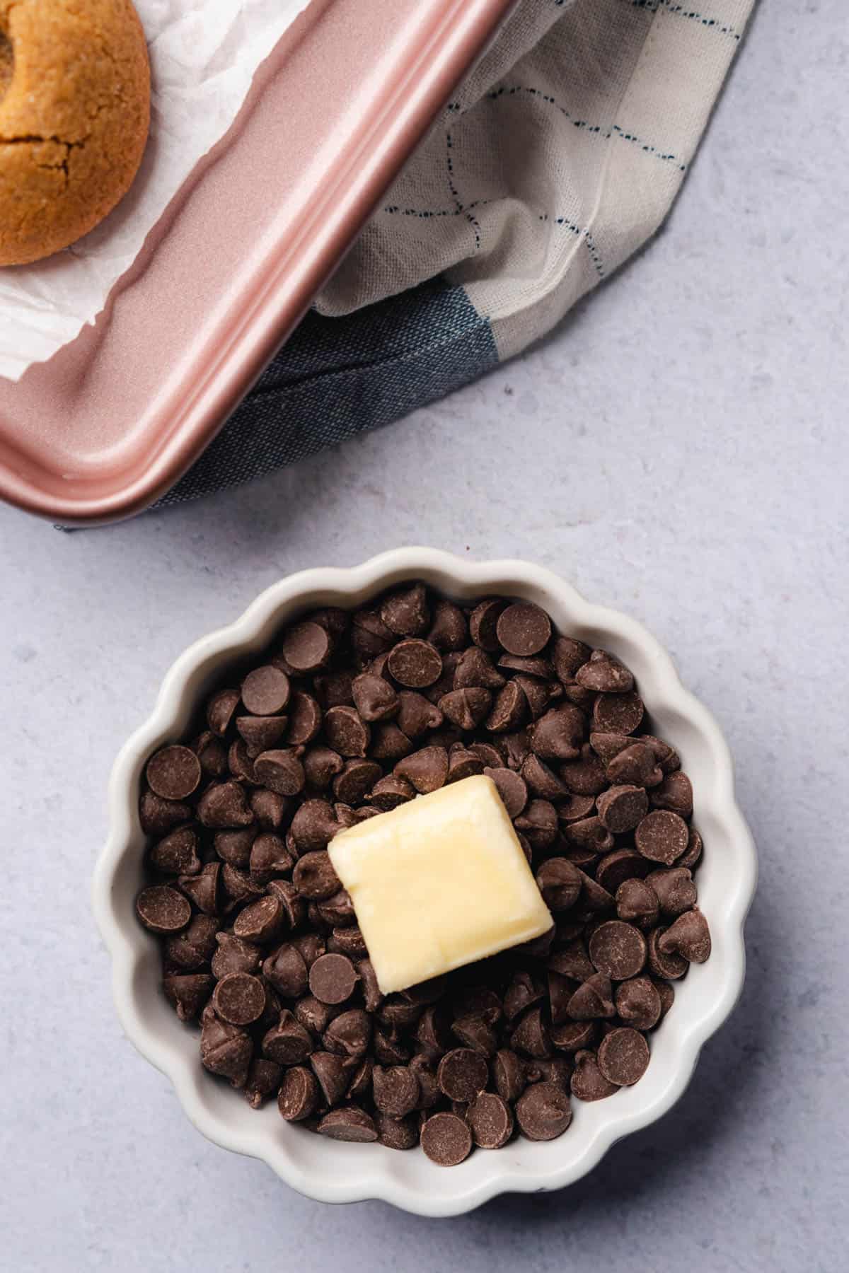 chocolate chips with a pat of butter in the center of a small ceramic dish