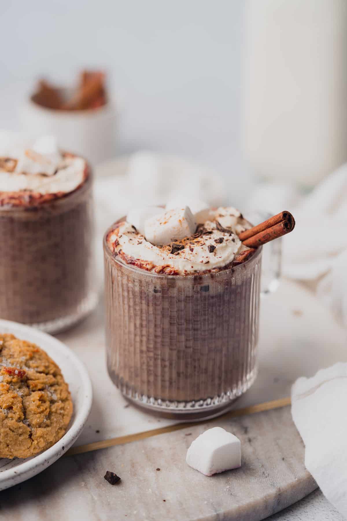 instant pot hot chocolate with marshmallows, whipped cream, and cinnamon sticks