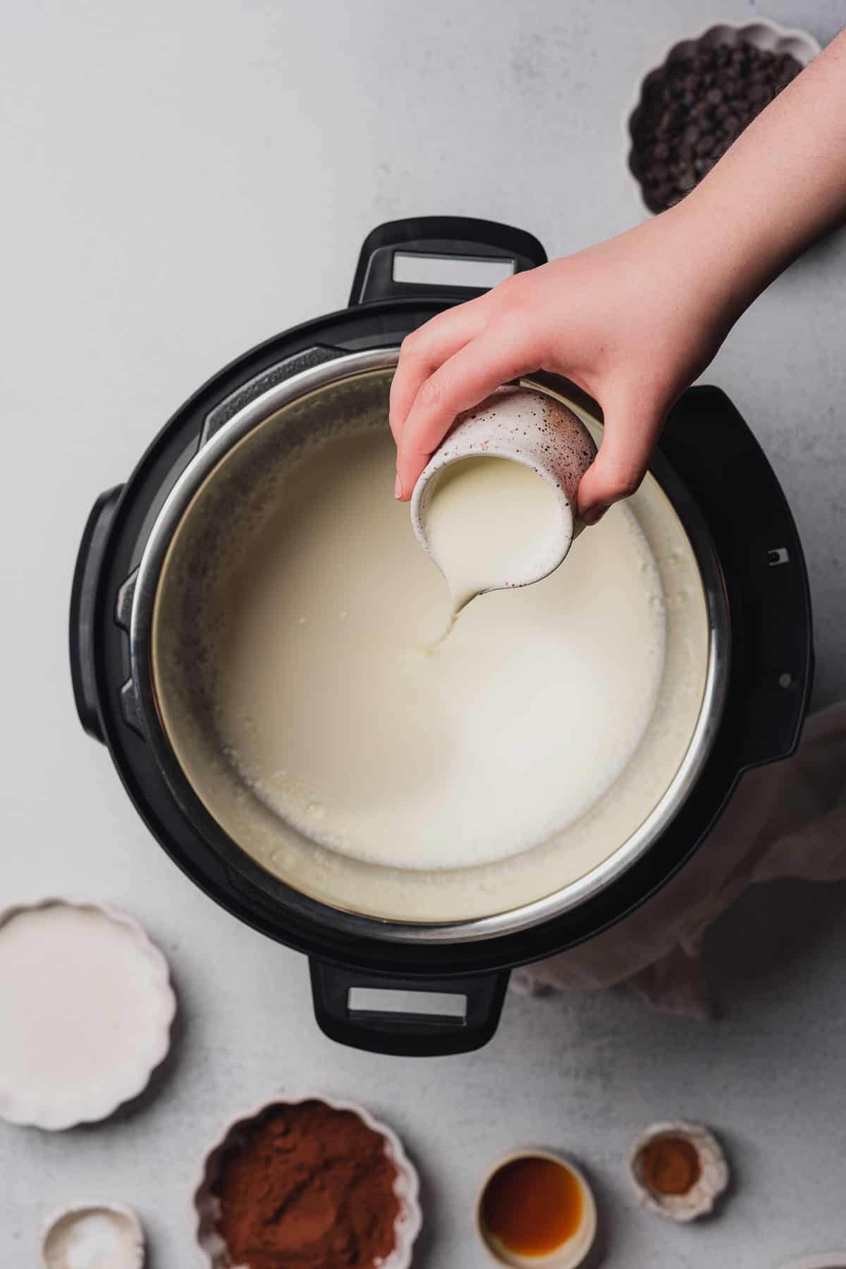 hand poring cream into an instant pot
