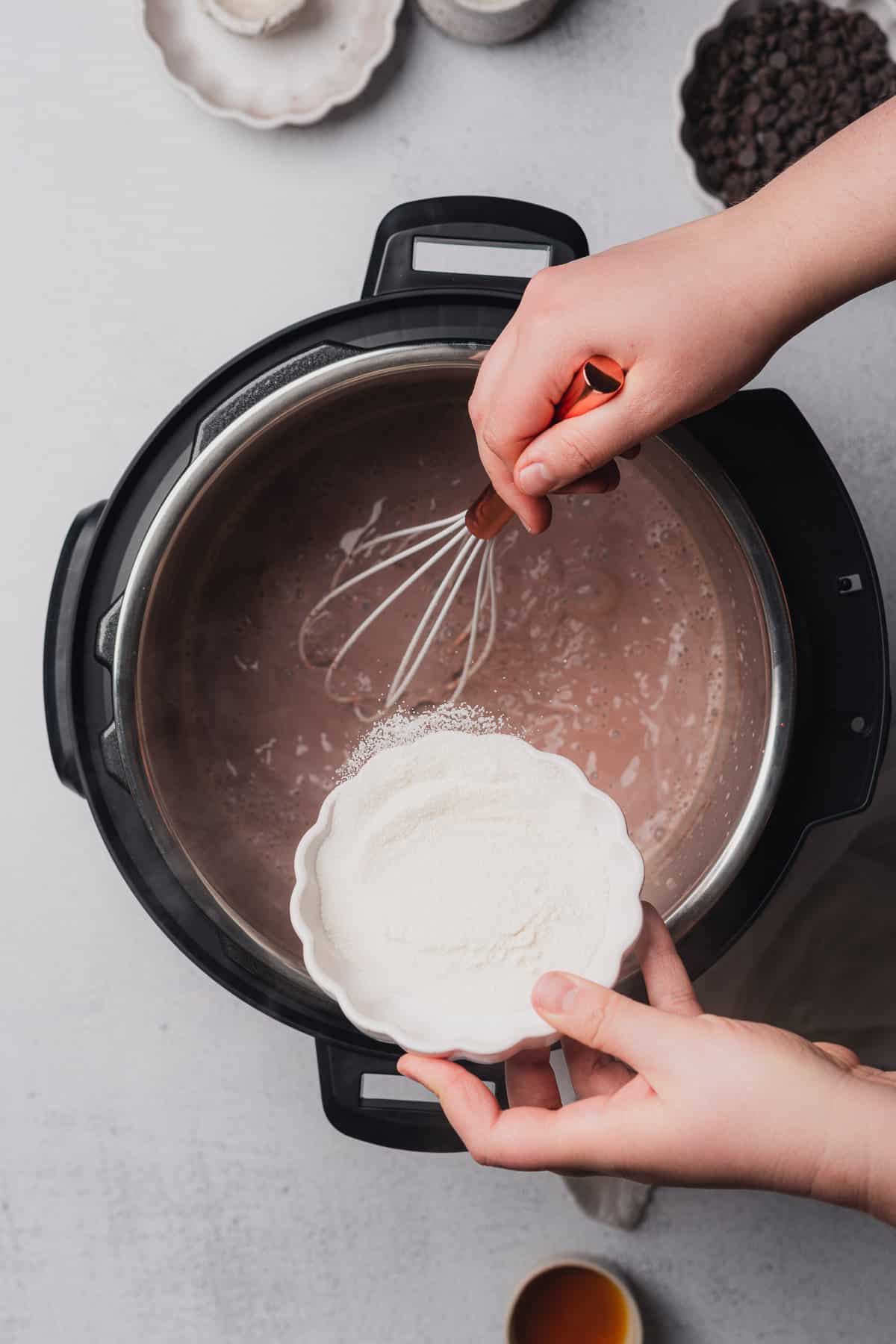 hand pouring in sweetener to an instant pot 