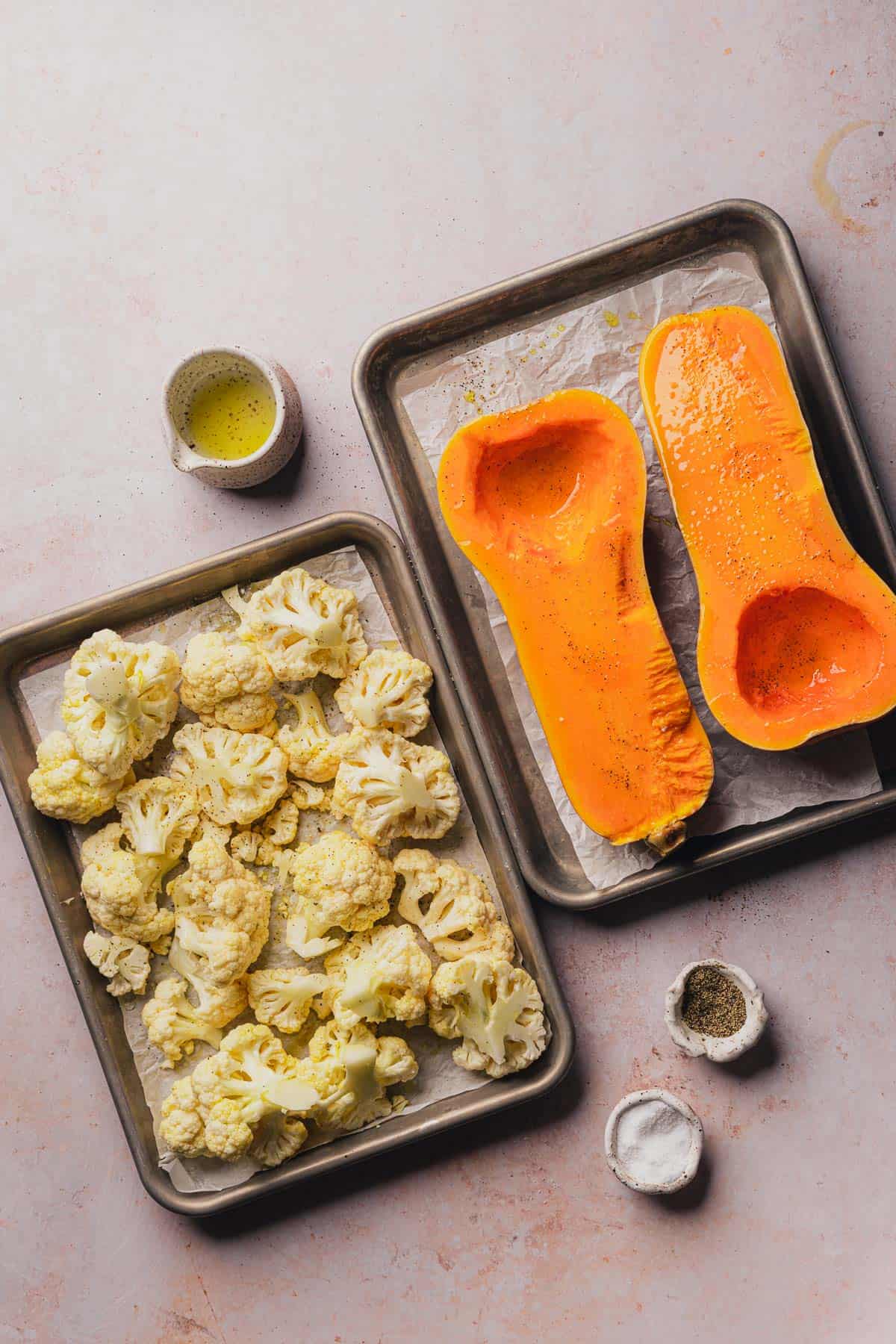 butternut squash and cauliflower on parchment lined baking sheets 