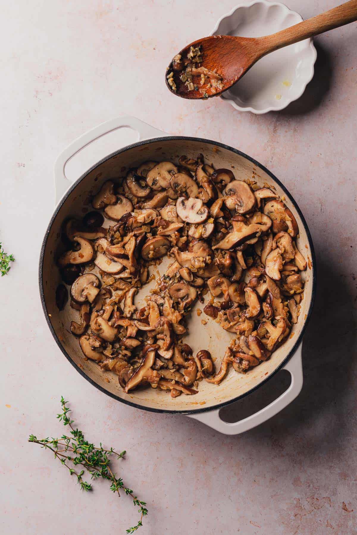cooked mushrooms in an enamel skillet with onions and garlic