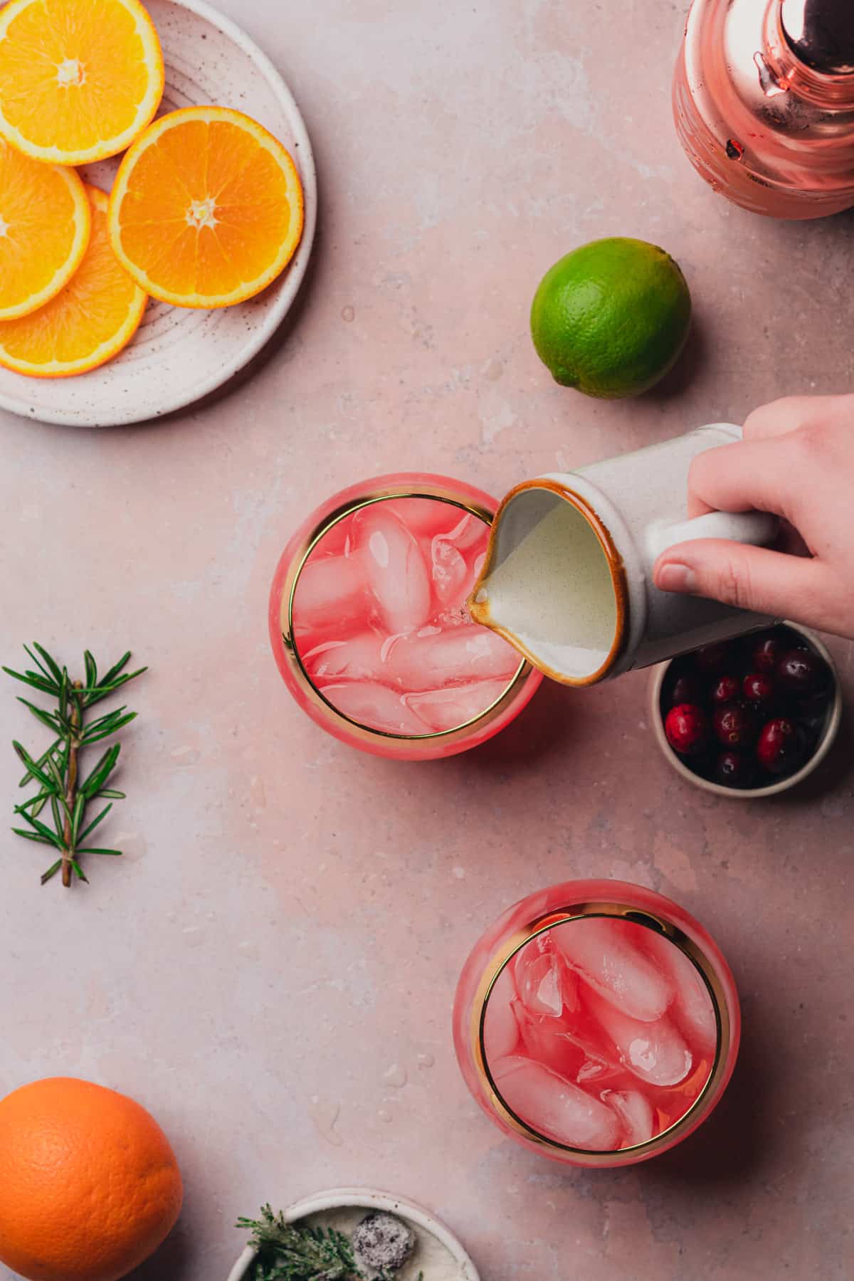 pouring prosecco into glasses with a cranberry cocktail 