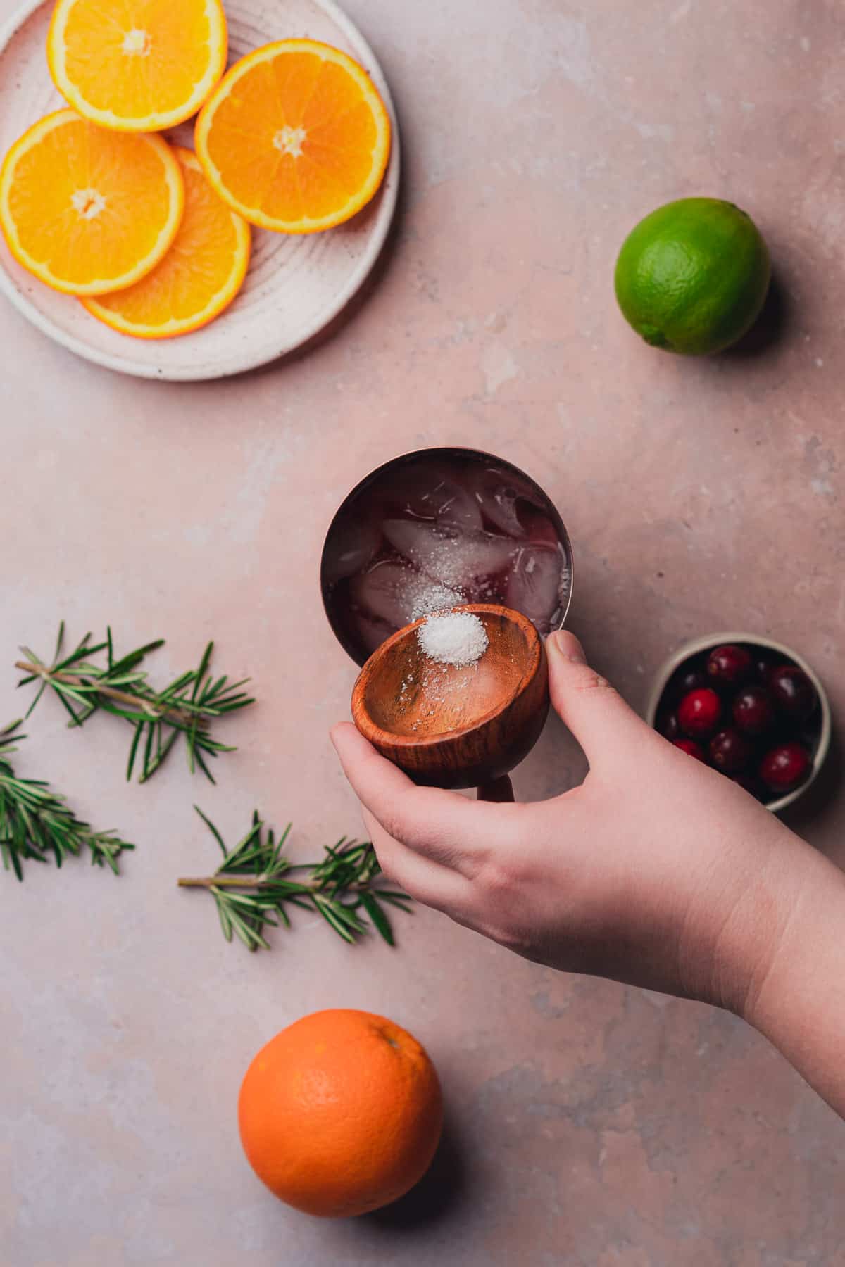 hand sprinkling in salt into a cocktail shaker