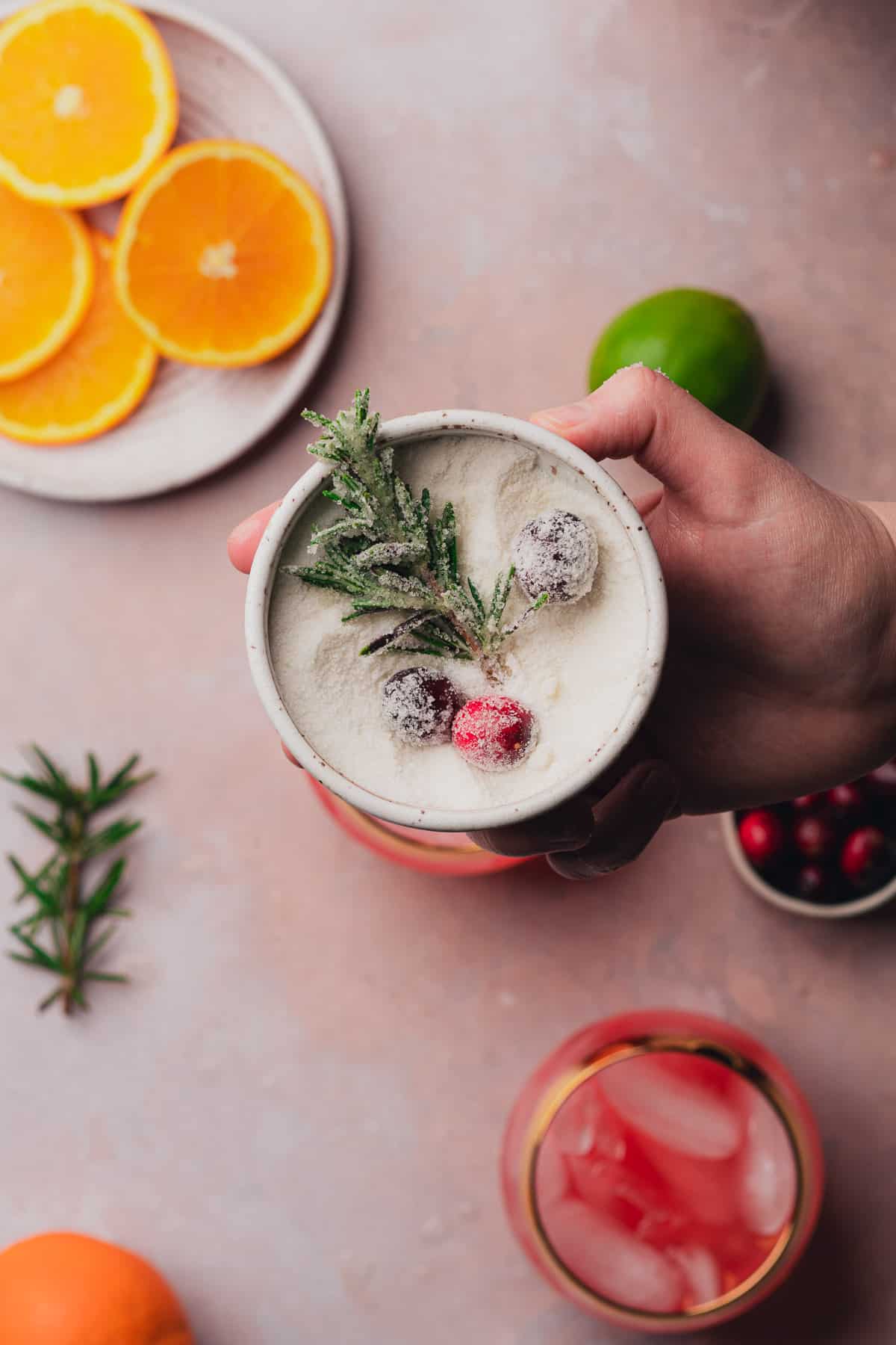 sugaring pieces of cranberries and rosemary to top drinks