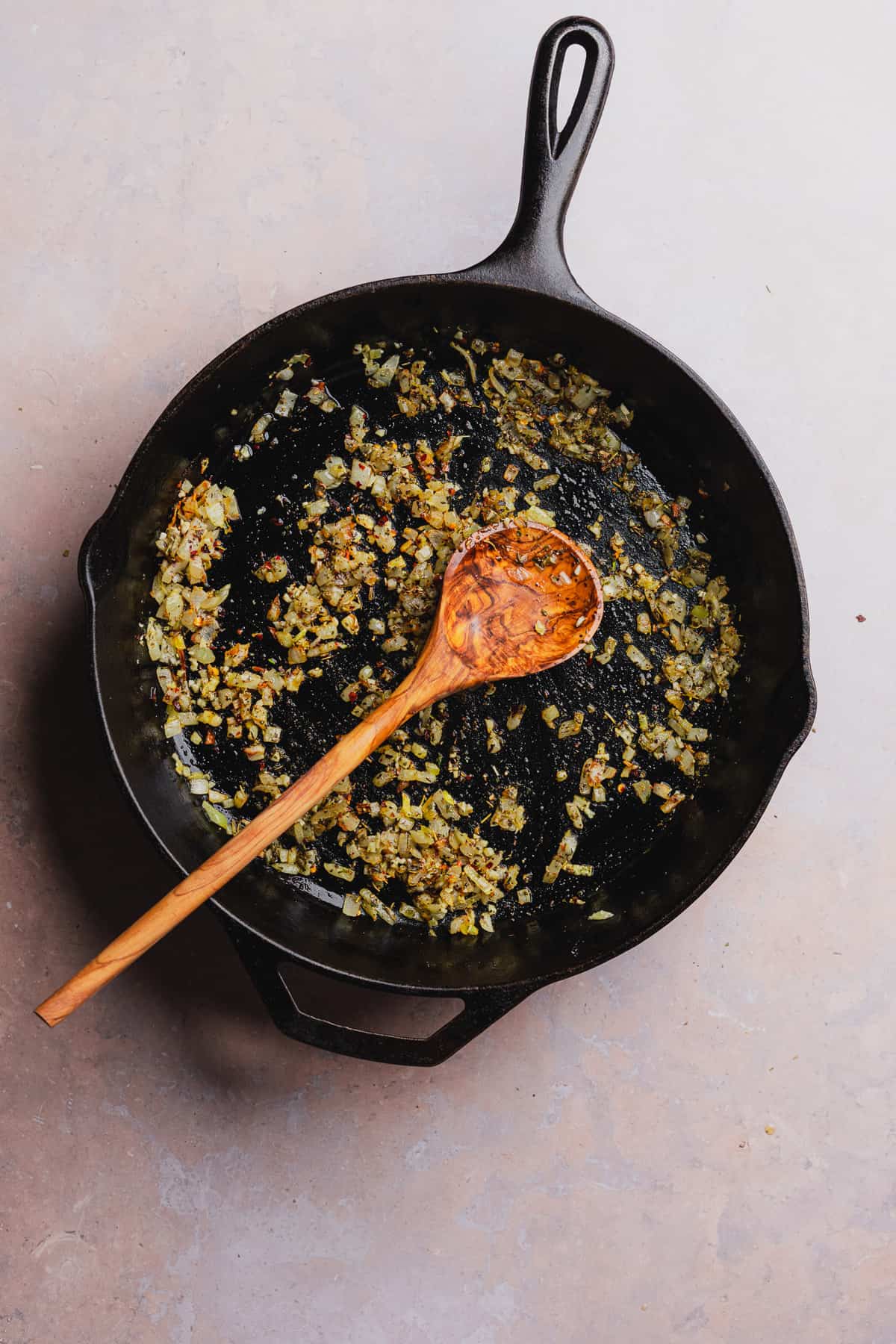 onion cooking in a cast iron skillet with seasonings 