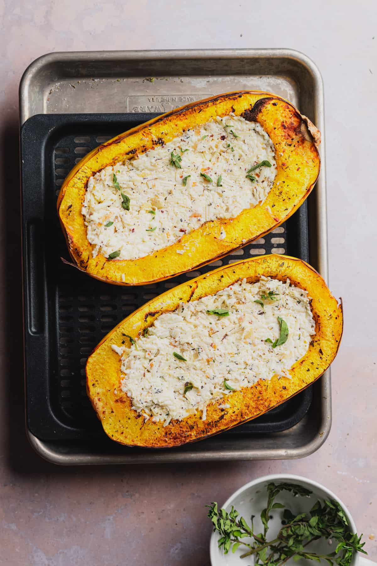 cooked spaghetti squash halves with herbed cheesy ricotta filling on the inside 