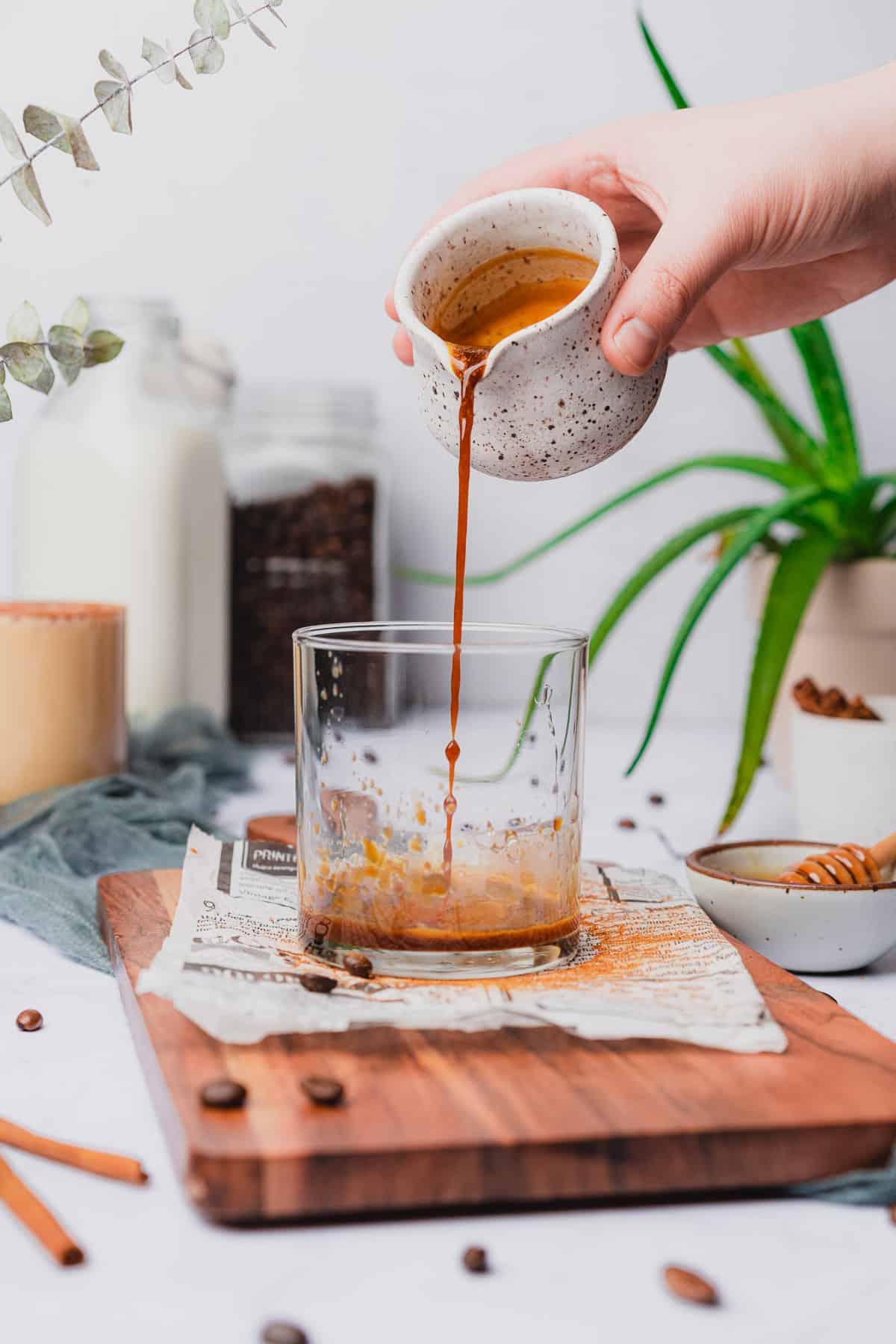 hand pouring espresso into a glass