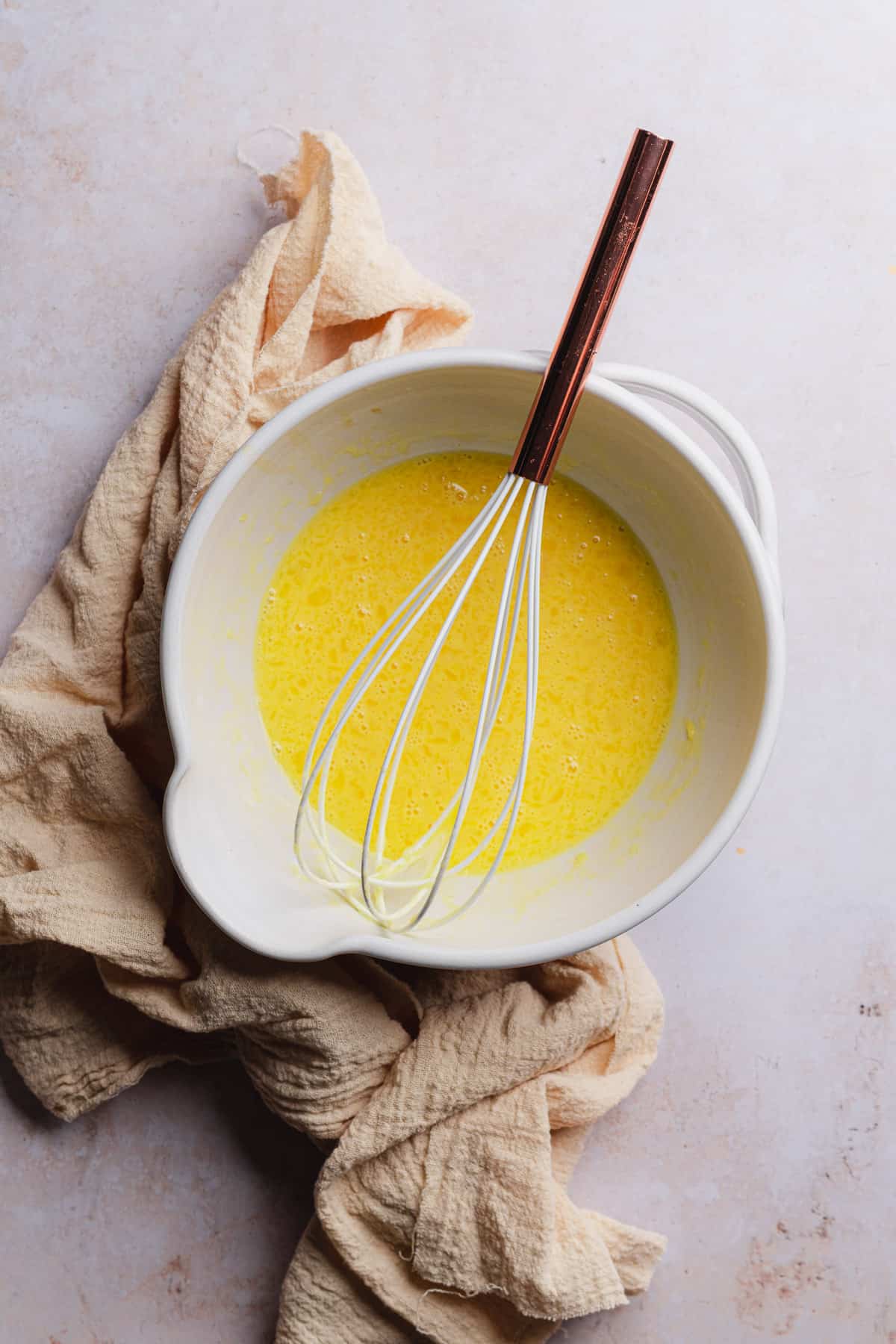 whisked eggs, vanilla, melted butter and milk in a ceramic mixing bowl