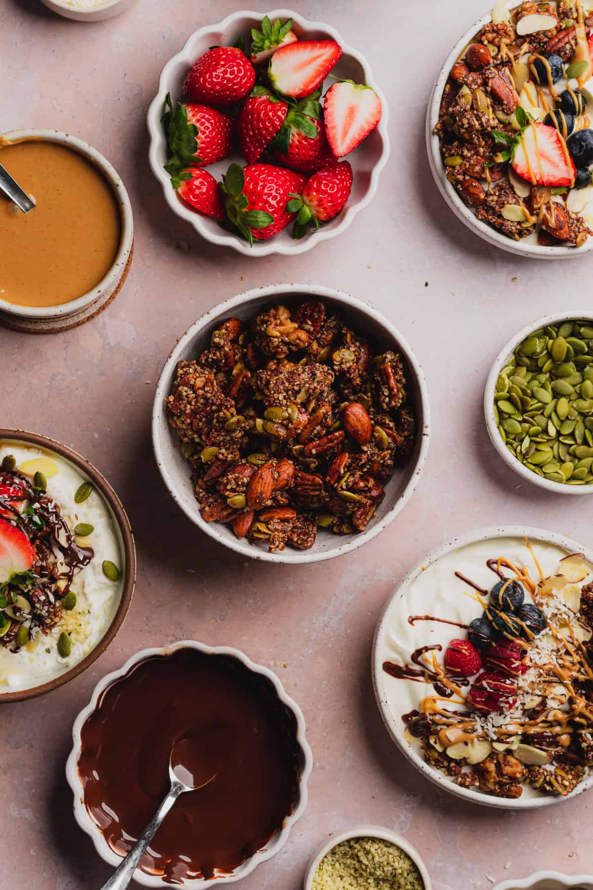 beautiful bowl of keto granolasurrounded by fresh fruit and yogurt bowls.