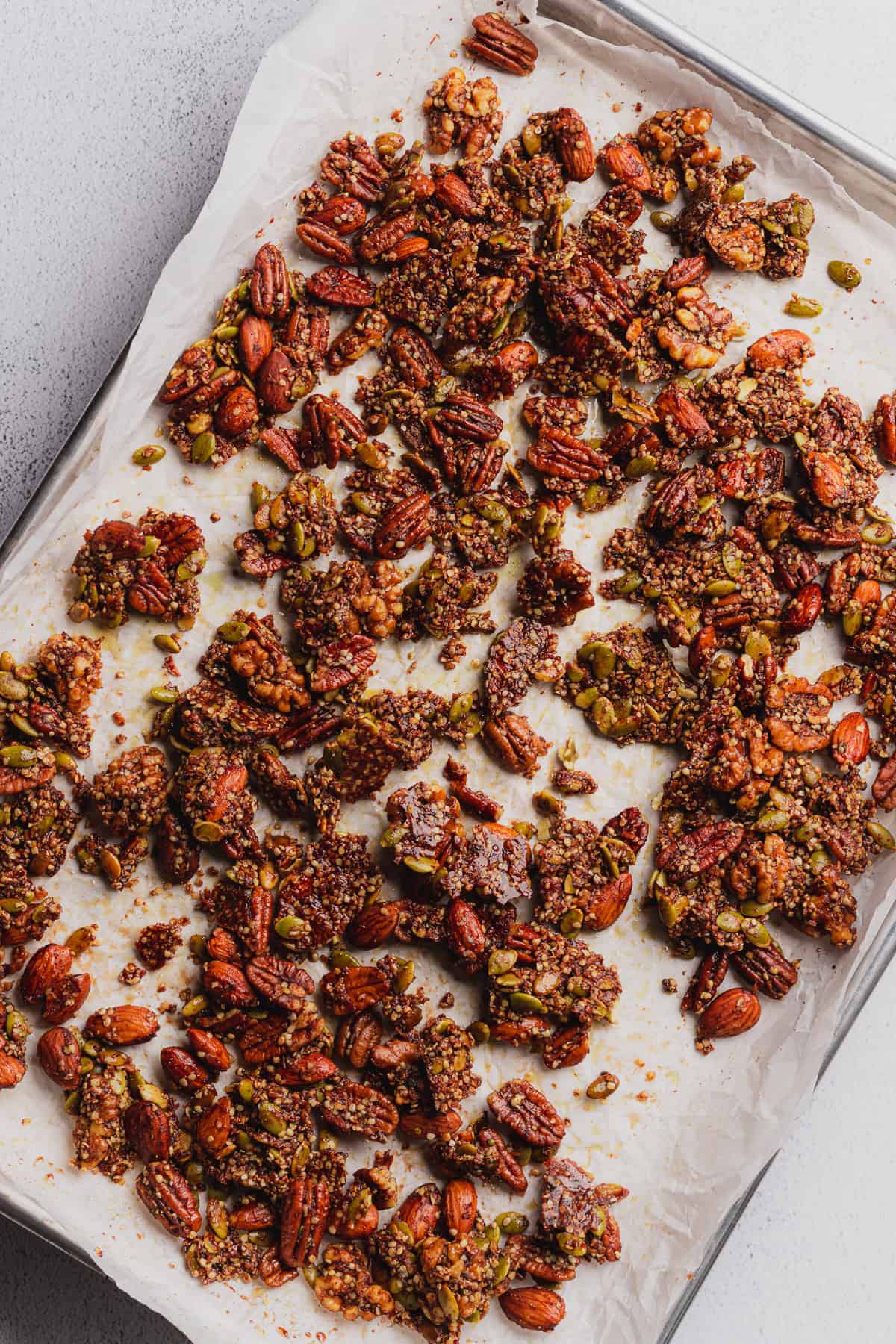keto granola snapped into pieces on a baking sheet lined with parchment paper. 