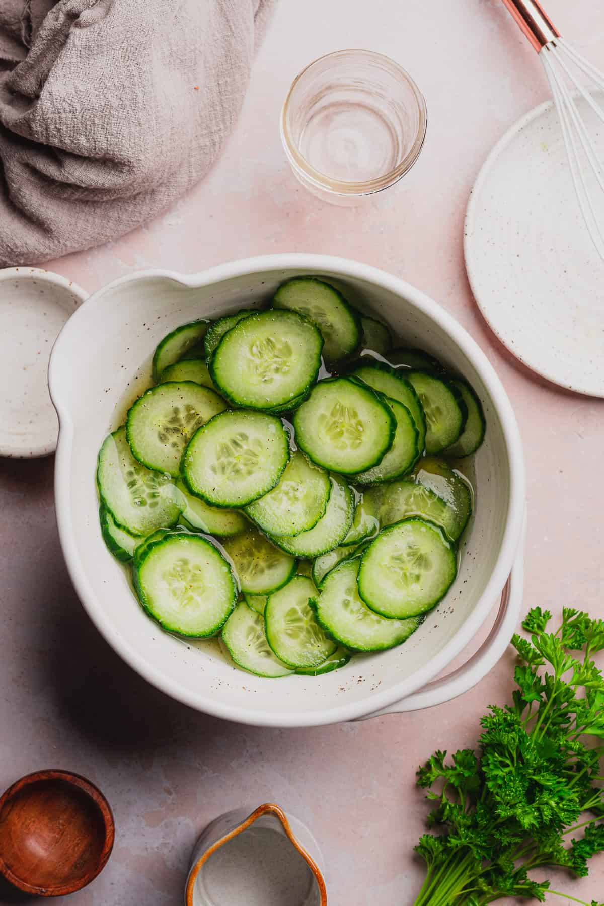 fresh bright green cucumber slices in a bowl of pickling liquid. 