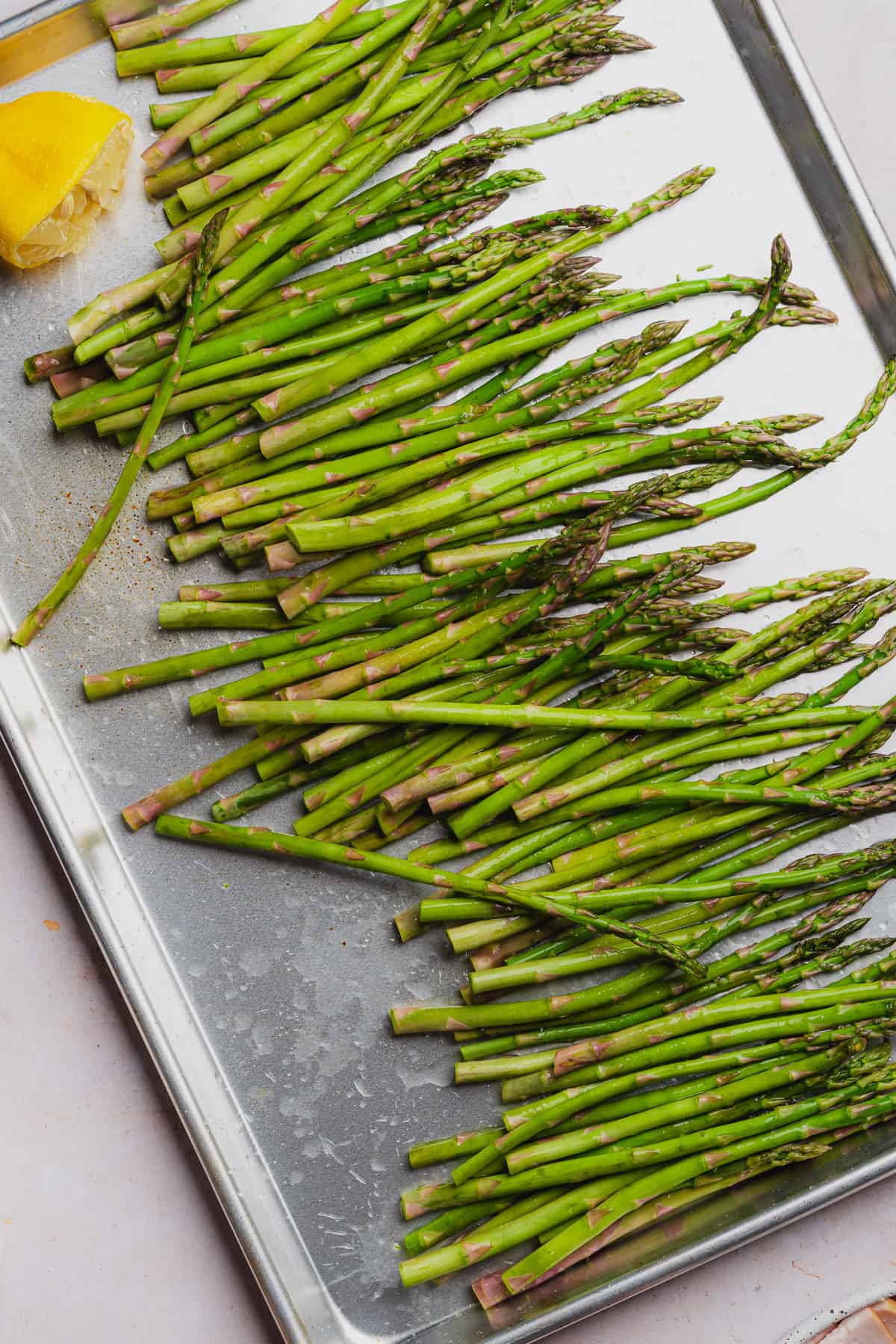 squeezing lemon juice over top of asparagus spears