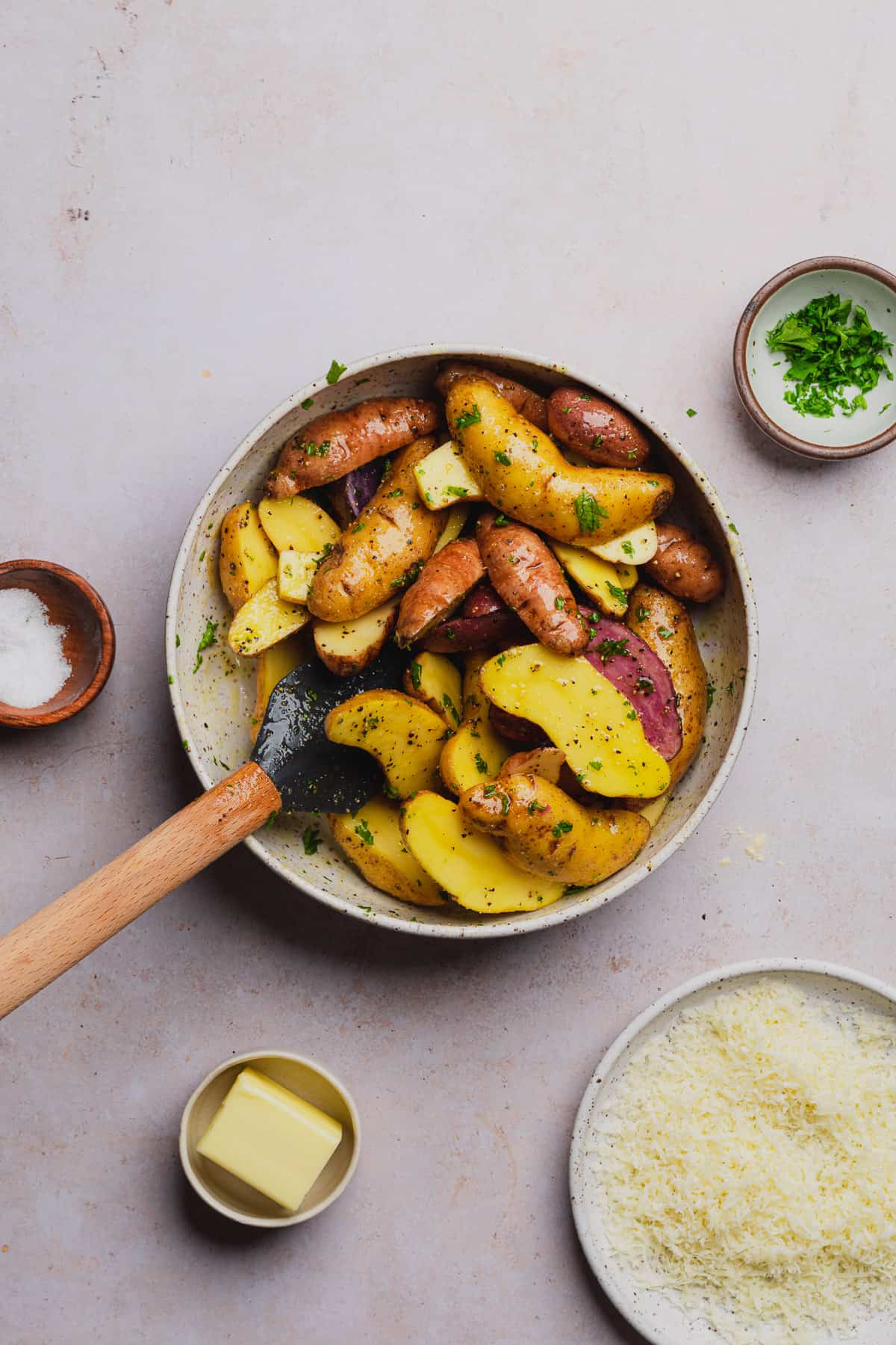 rubber spatula in a bowl of fingerling potatoes 