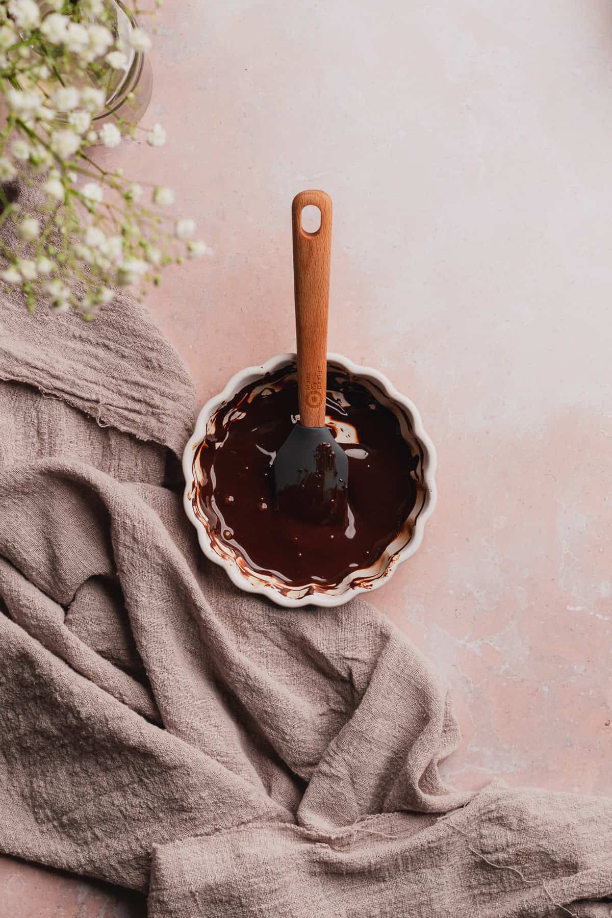 melted chocolate in a ramekin with a rubber spatula 