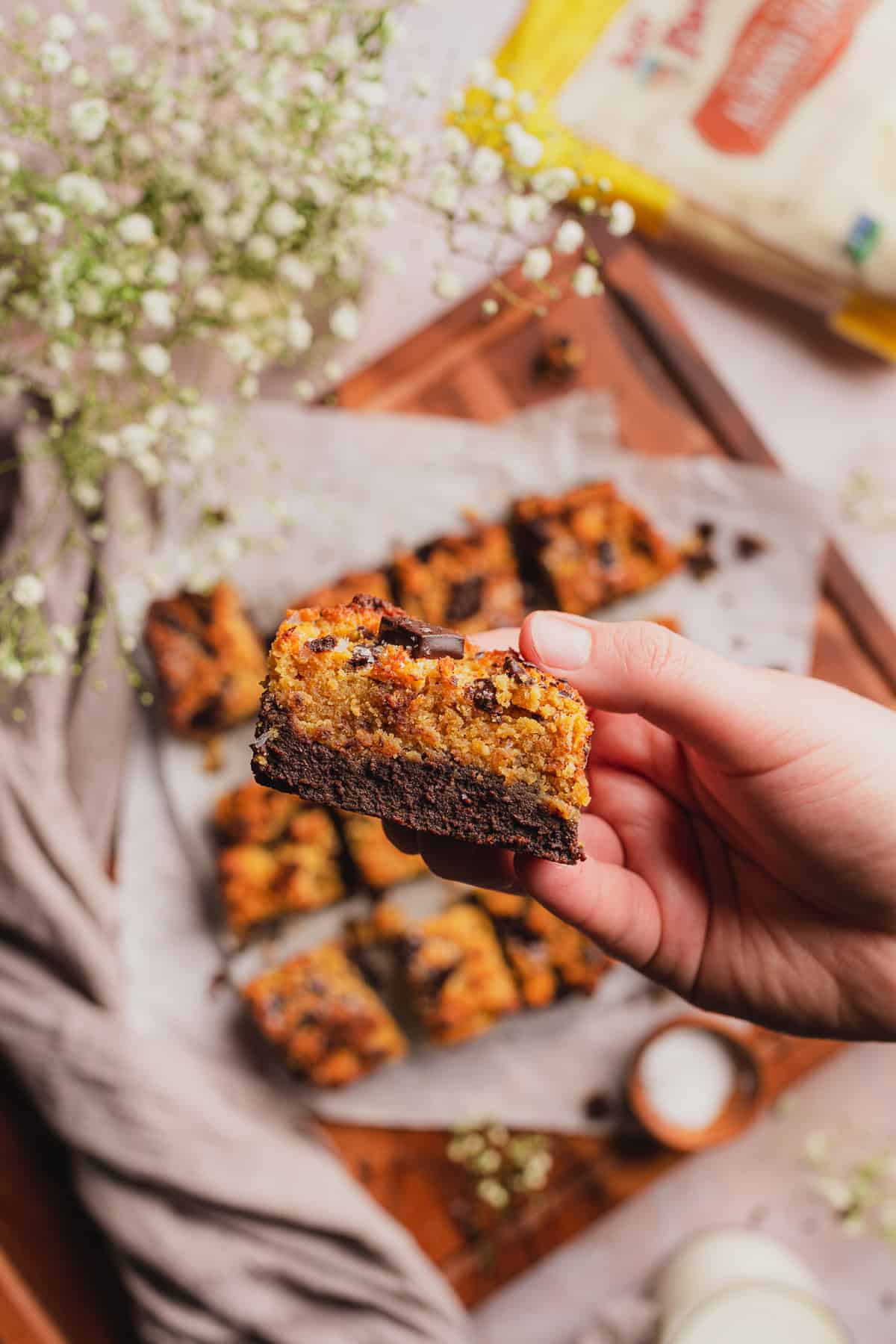 hand holding a brownie blondie up to the screen to show the inside texture 