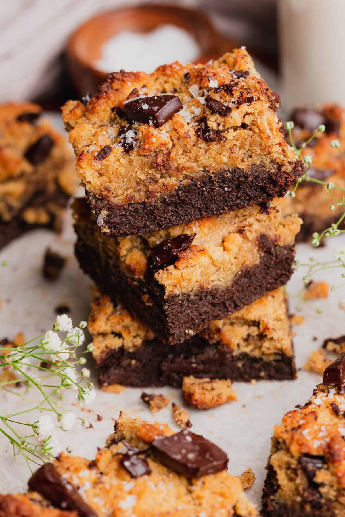 stack of delicious brownie blondies with little white flowers surrounding it