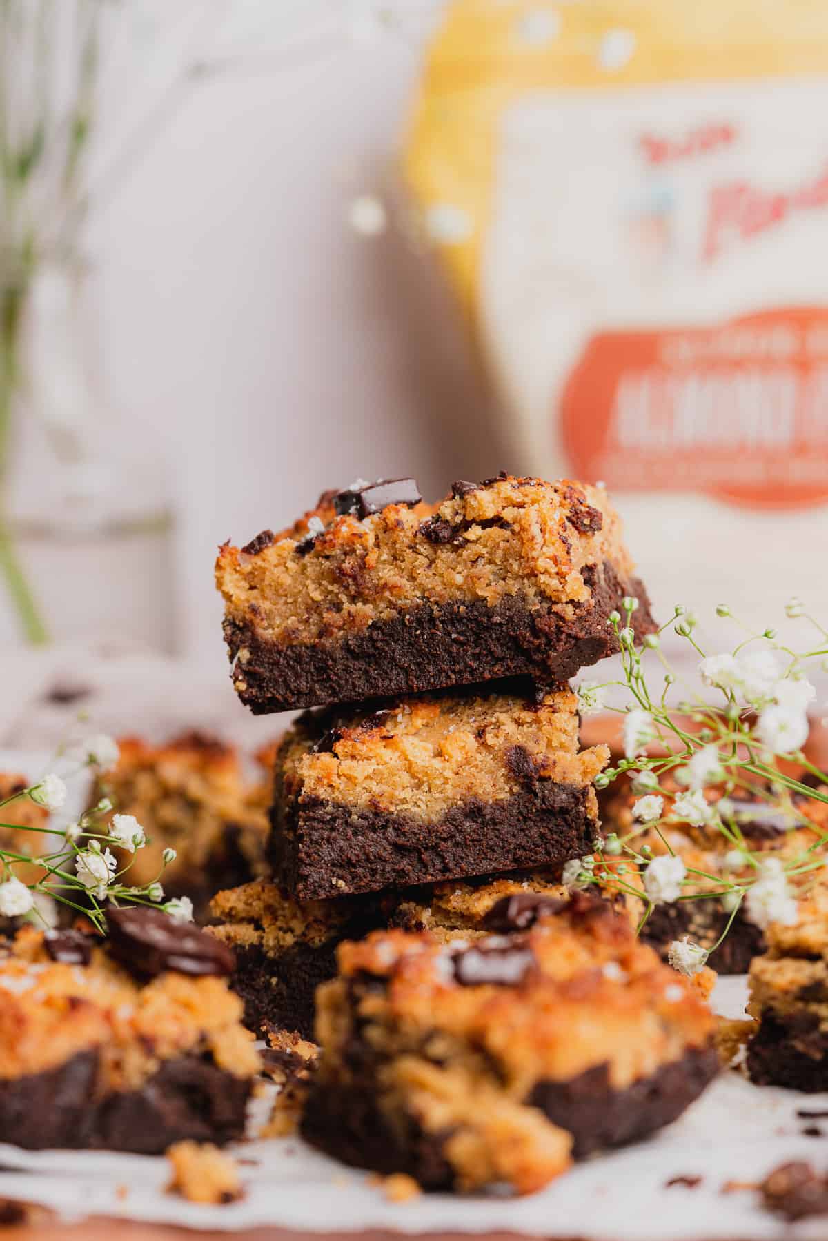 stack of brownie blondies with white baby's breath and a bag of bob's red mill almond flour in the back