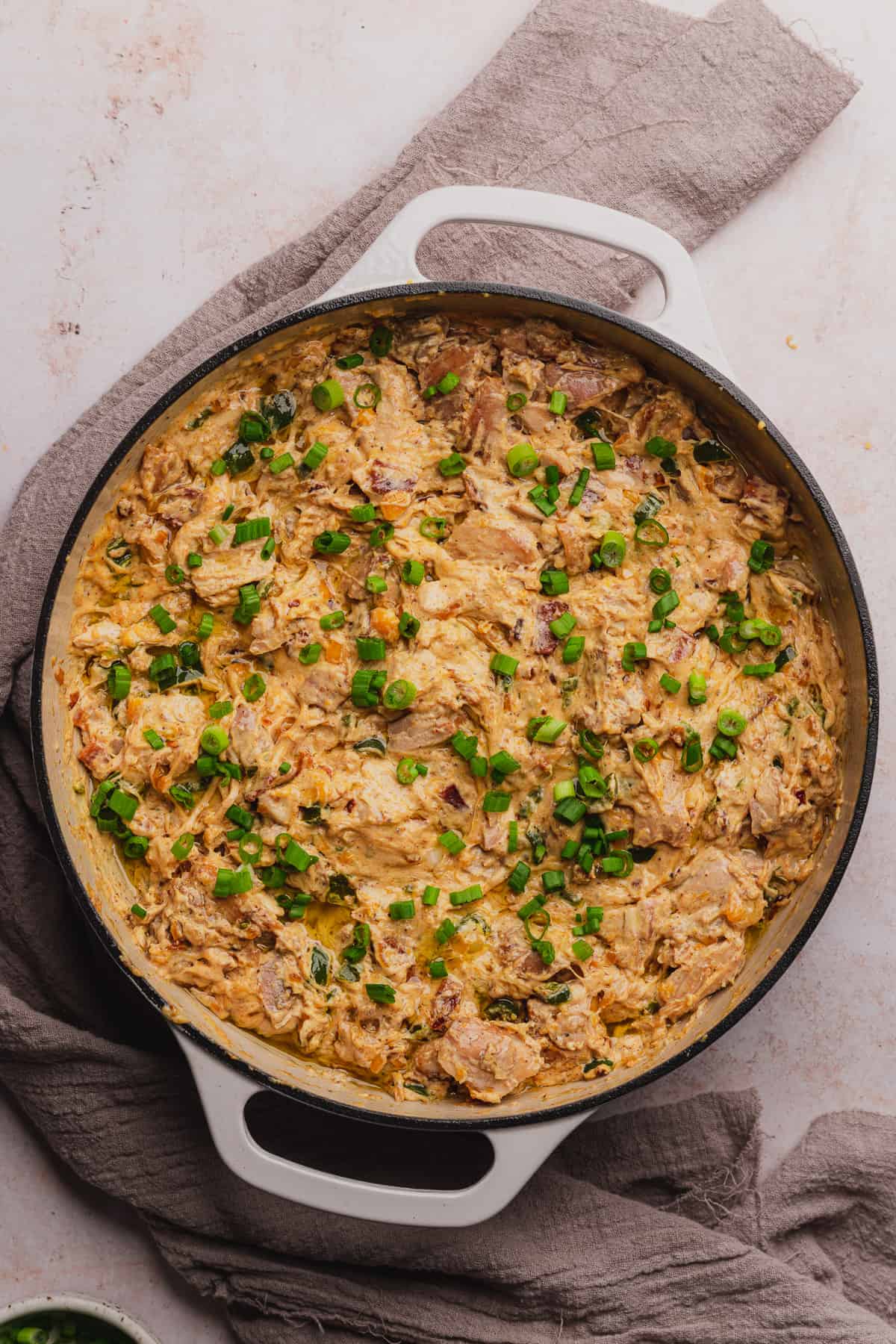 green onions on top of creamy chicken mixture in a skillet 