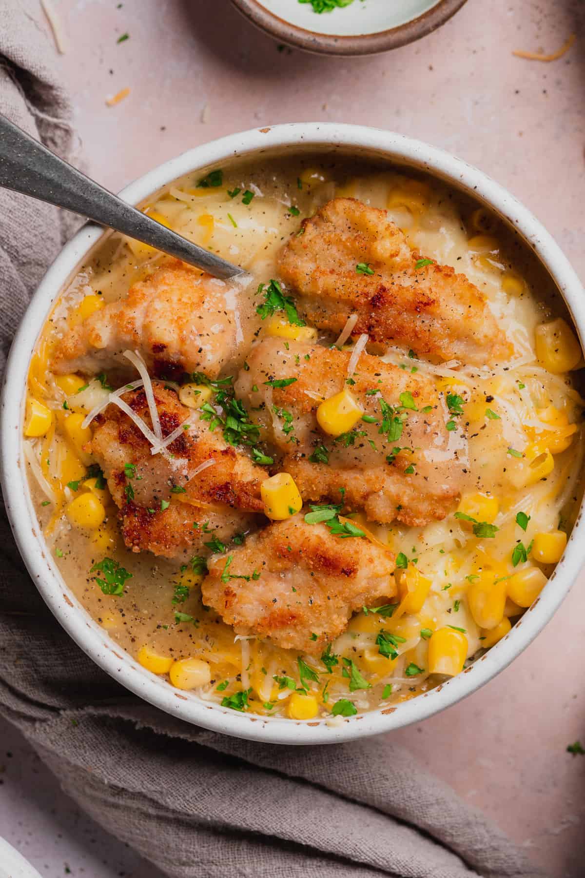 close up shot of a homemade KFC famous bowl with sweet corn, gray, chicken tenders, cheese, and homestyle gravy over mashed potatoes. 
