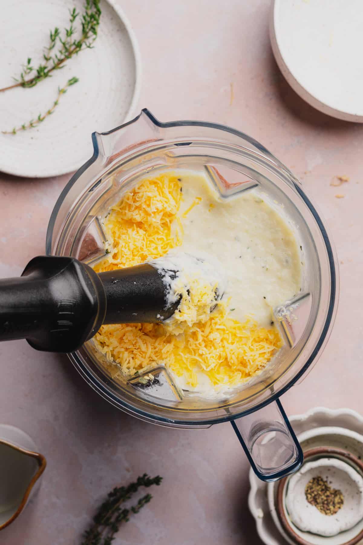 tampering shredded cheese in a blender full of mashed turnips. 
